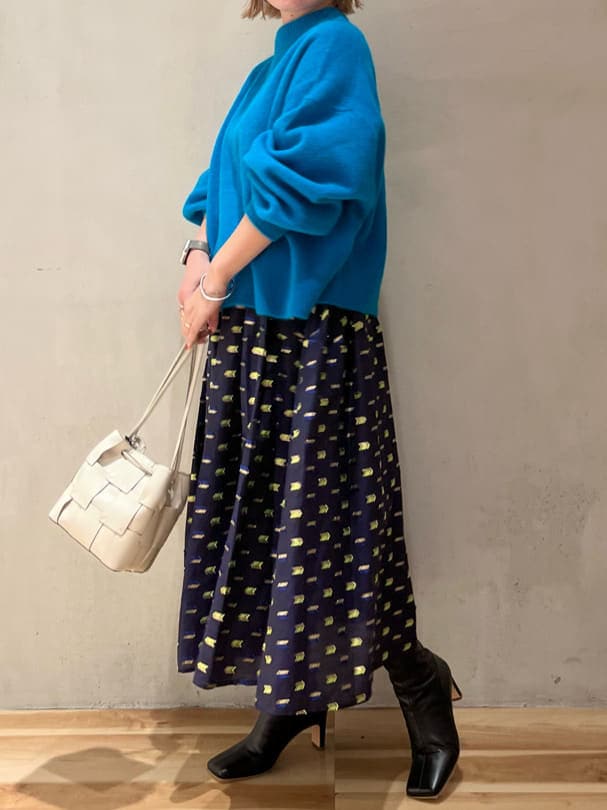 ブラック系のブーツ、ブルー系のスカート、ブルー系のニット/セーターを着用したレディースの秋コーディネートの2枚目の写真