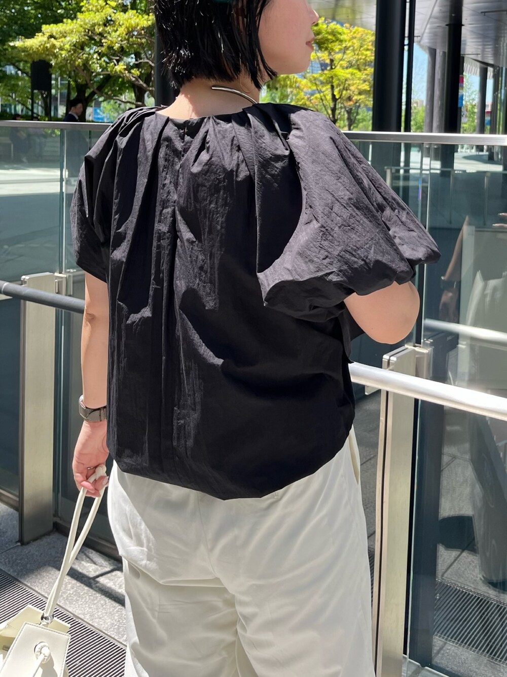 ブラック系のシャツ/ブラウス、ホワイト系のその他パンツ、ブラック系のサンダルを着用したレディースの春コーディネートの7枚目の写真