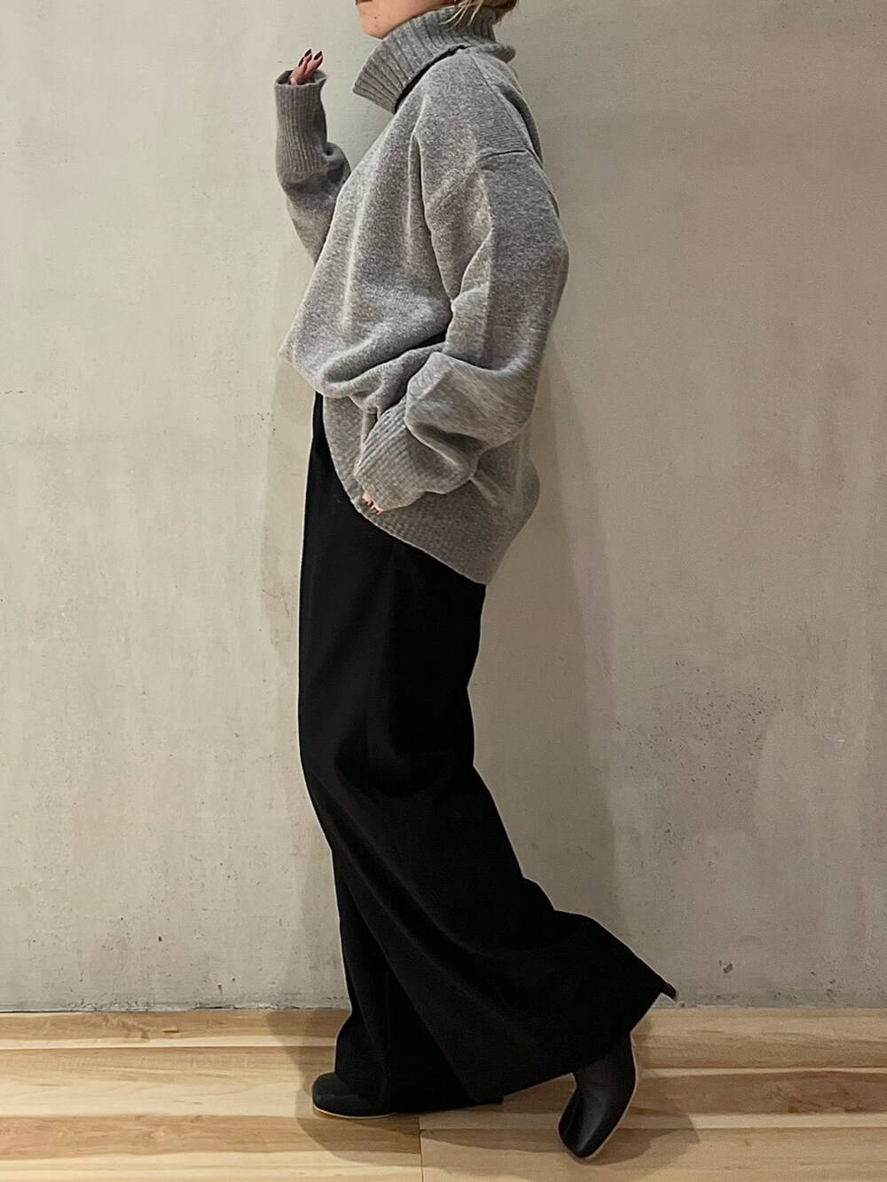 グレー系のニット/セーター、ブラック系のその他パンツ、ブラック系のブーツを着用したレディースの秋コーディネートの5枚目の写真
