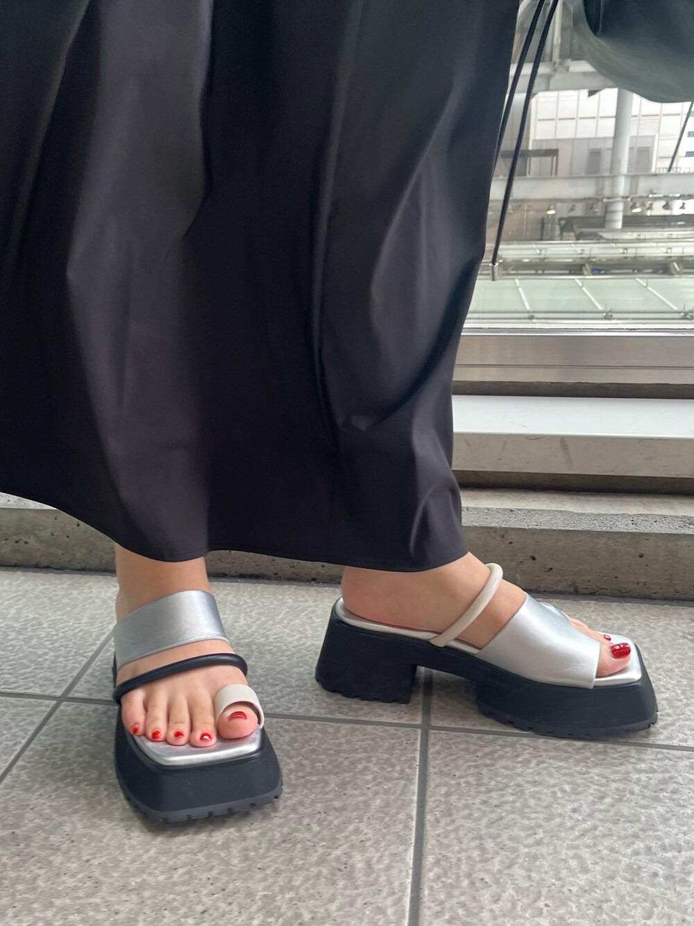 ブラック系のワンピース、ブラック系のショルダーバッグ、その他のサンダルを着用したレディースの春コーディネートの7枚目の写真