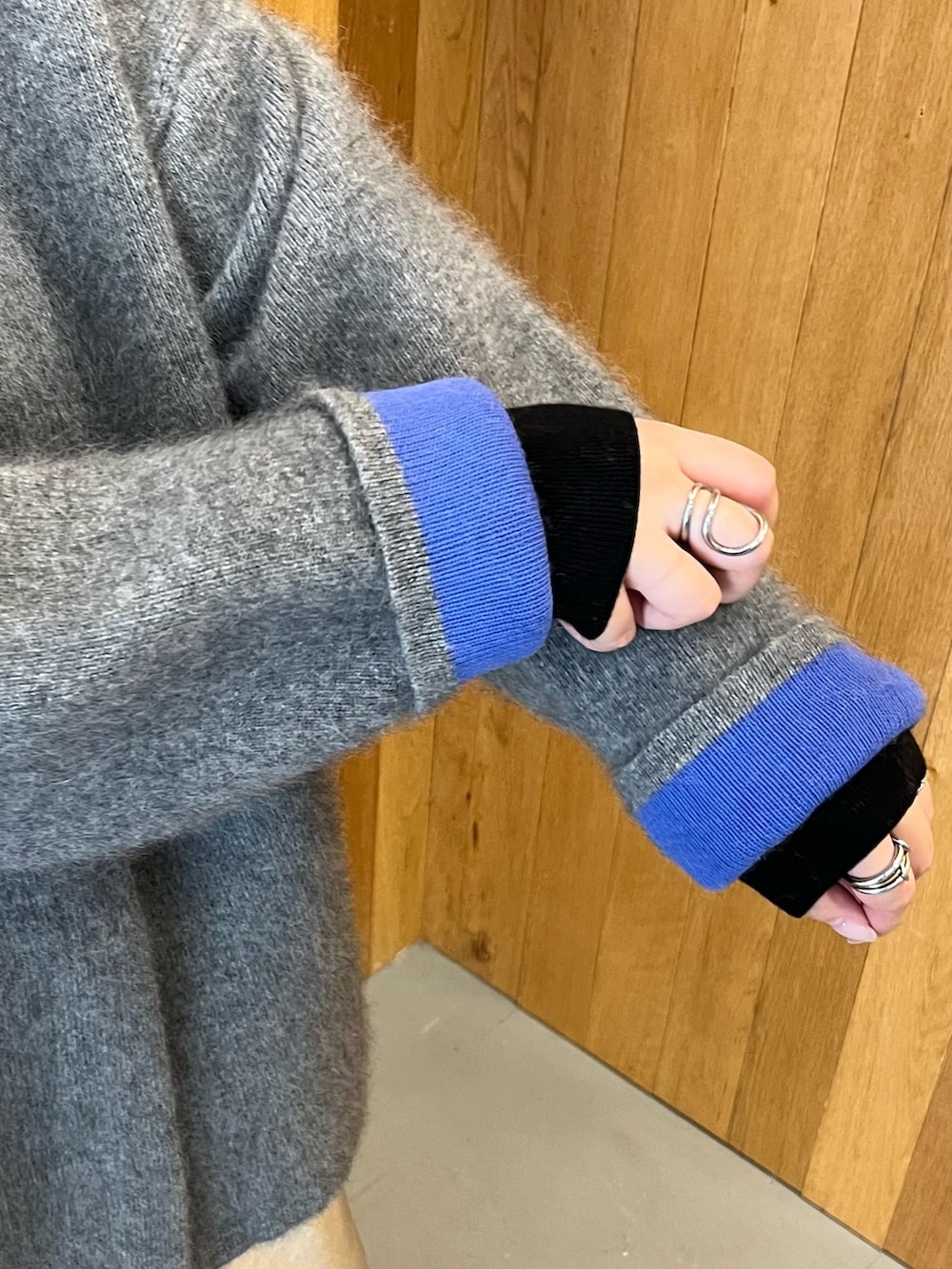 グレー系のカーディガン/ボレロ、シルバー系のスカート、ブラック系のブーツを着用したレディースの秋コーディネートの9枚目の写真