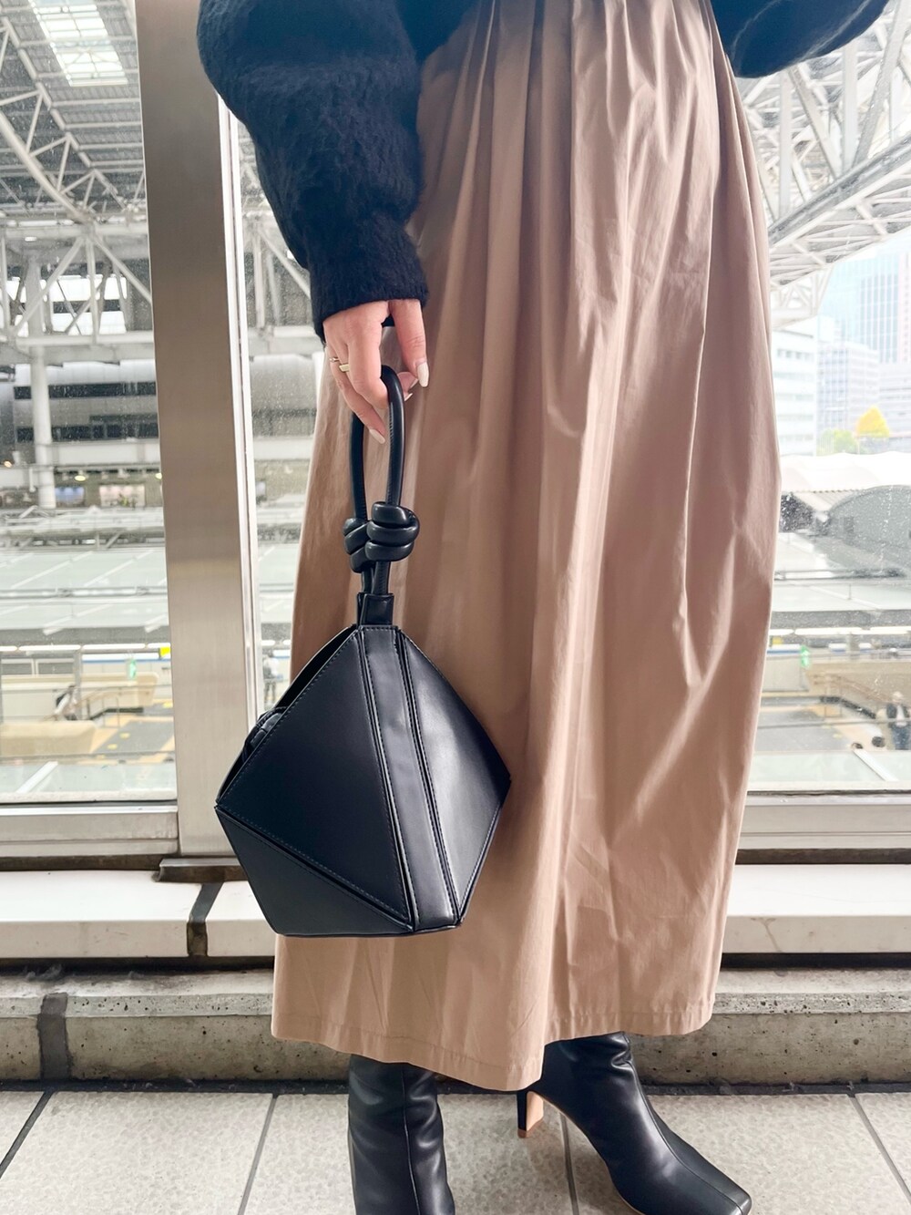 ブラック系のワンピース、ブラック系のハンドバッグ、ブラック系のブーツを着用したレディースの秋コーディネートの6枚目の写真