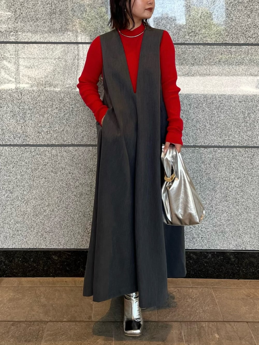 グレー系のジャンパースカート、シルバー系のブーツ、ゴールド系のハンドバッグを着用したレディースの夏コーディネートの5枚目の写真