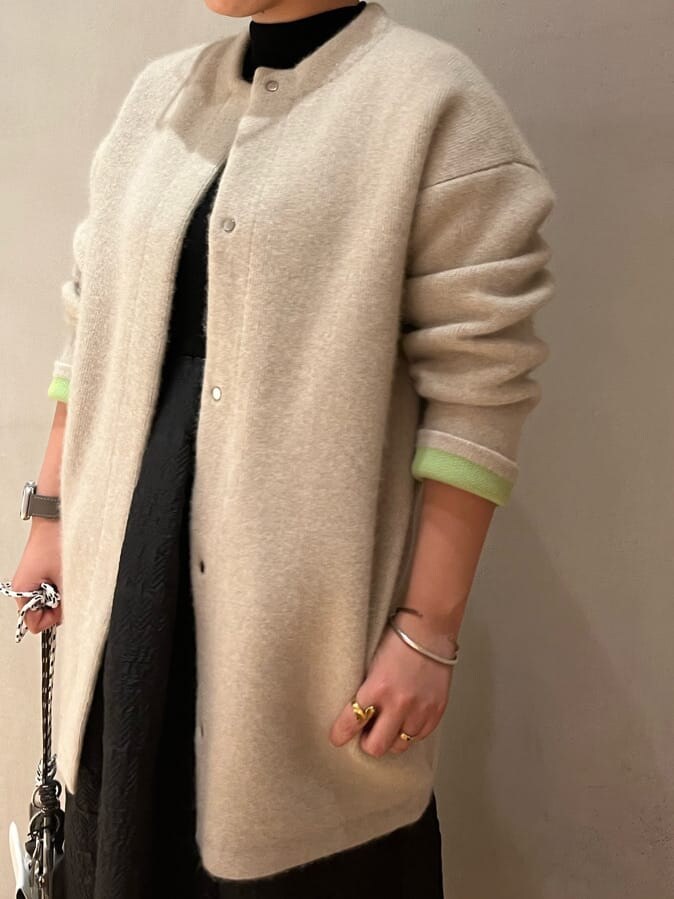 ベージュ系のショルダーバッグ、ホワイト系のカーディガン/ボレロ、ブラウン系のブーツを着用したレディースの秋コーディネートの7枚目の写真