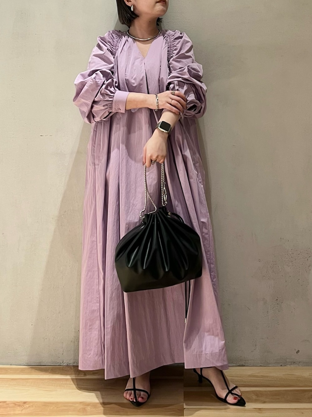 パープル系のワンピース、ブラック系のショルダーバッグを着用したレディースの春コーディネートの3枚目の写真