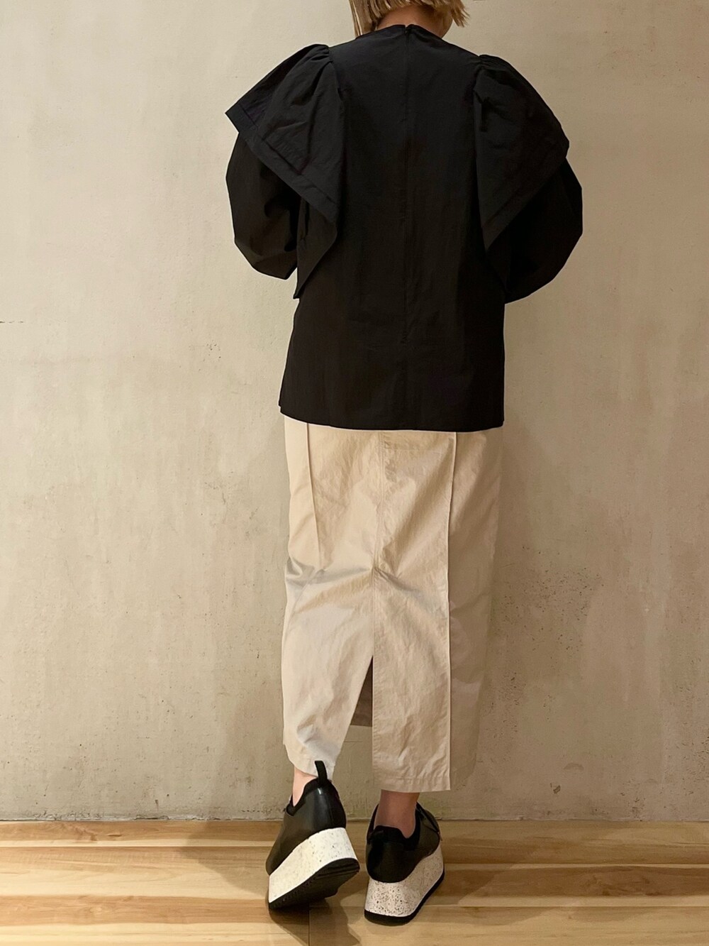 ブラック系のスニーカー、ブラック系のシャツ/ブラウス、ベージュ系のスカートを着用したレディースの冬コーディネートの3枚目の写真