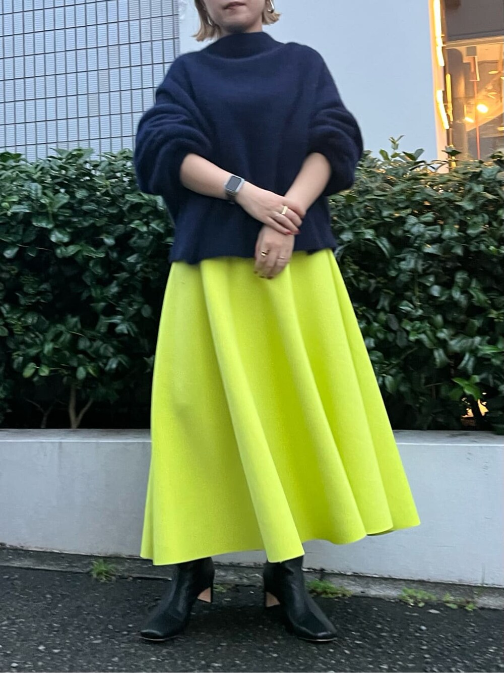 ベージュ系のダウンジャケット/コート、ブルー系のニット/セーター、イエロー系のスカートを着用したレディースの秋コーディネートの7枚目の写真