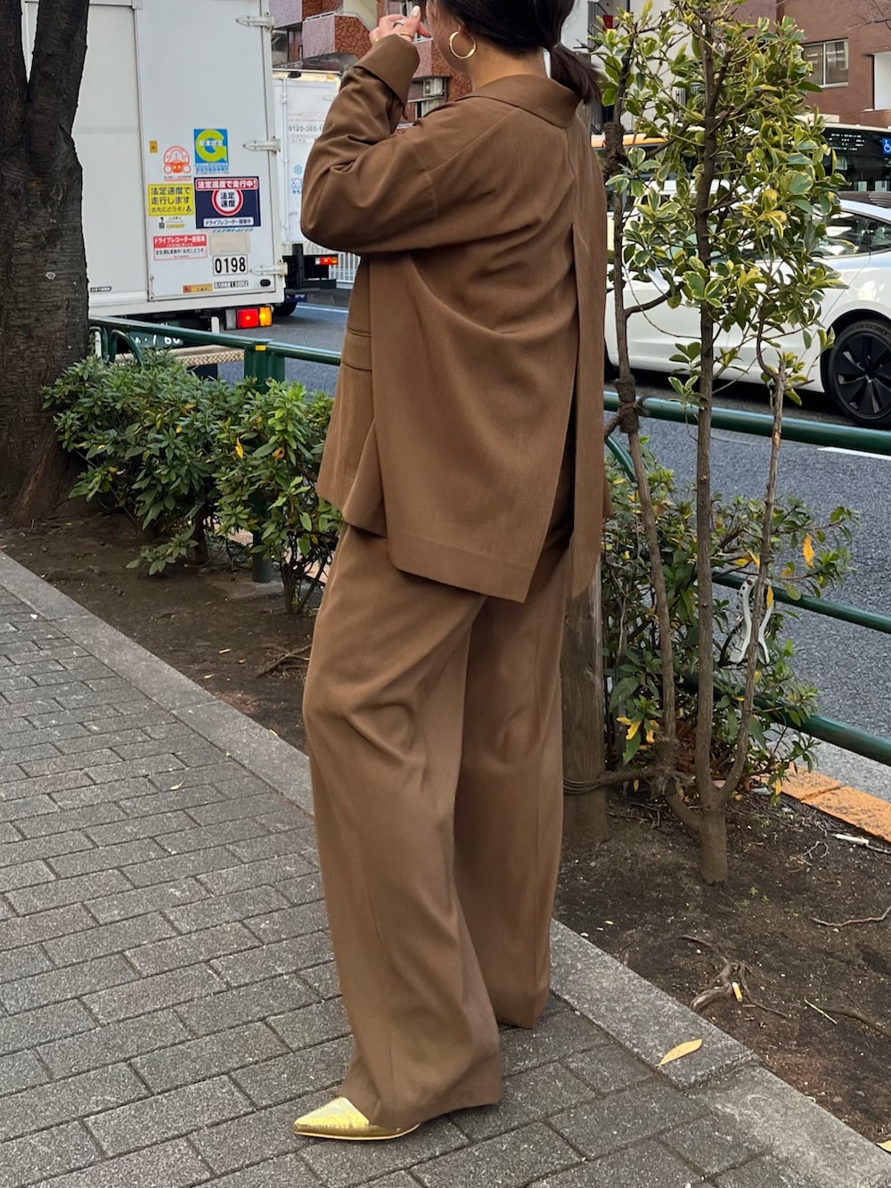 ブラウン系のテーラードジャケット、ブラウン系のその他パンツ、ゴールド系のサンダルを着用したレディースの冬コーディネートの5枚目の写真