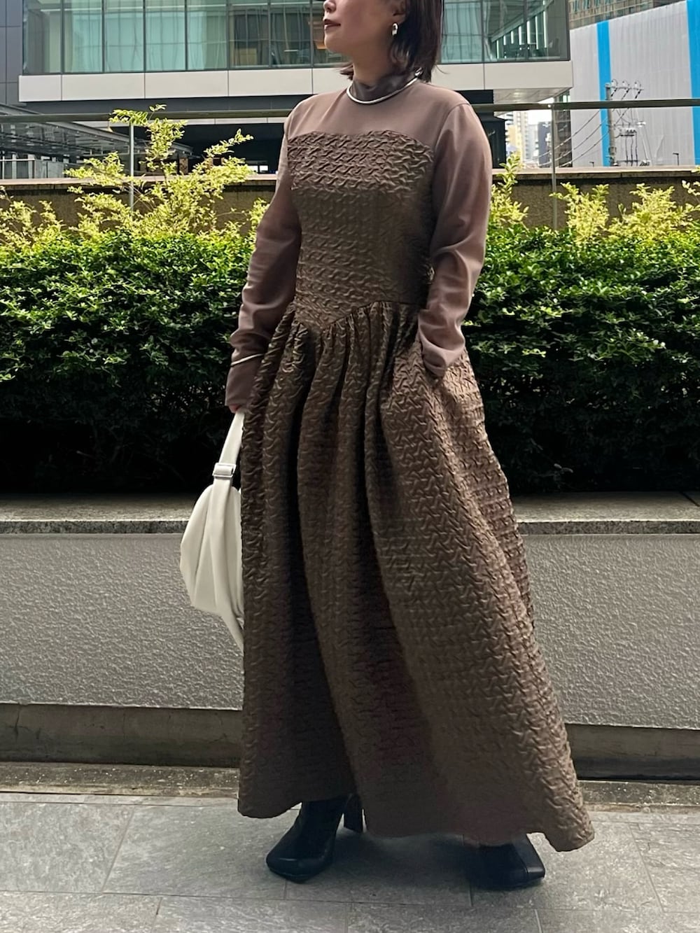 パープル系のカーディガン/ボレロ、ホワイト系のハンドバッグ、ベージュ系のワンピースを着用したレディースの夏コーディネートの7枚目の写真