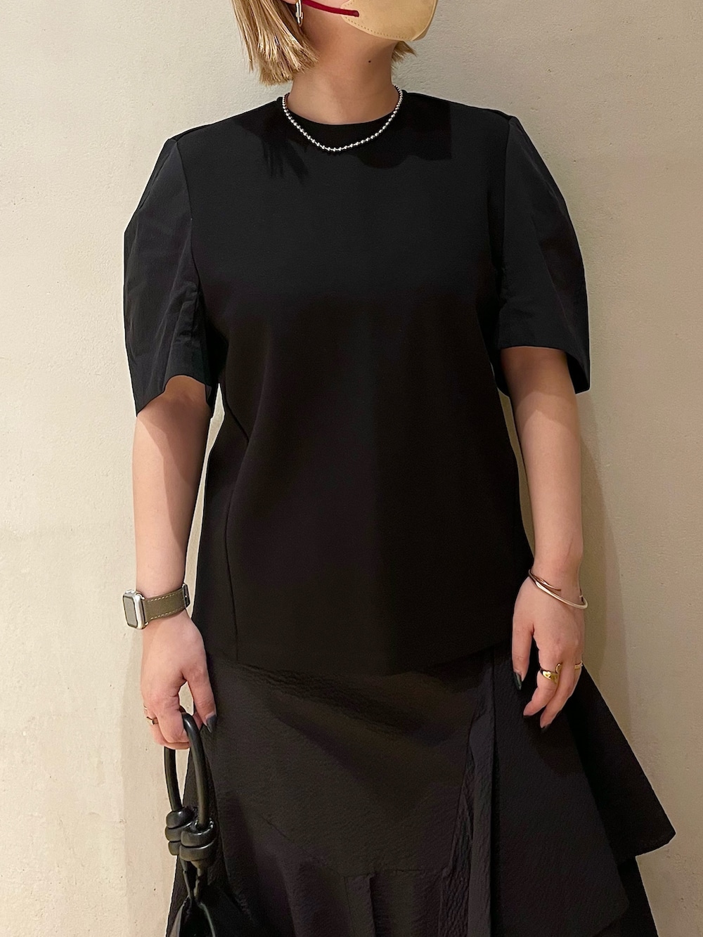 ブラック系のTシャツ/カットソー、ブラック系のスカート、ブラック系のハンドバッグを着用したレディースの春コーディネートの5枚目の写真