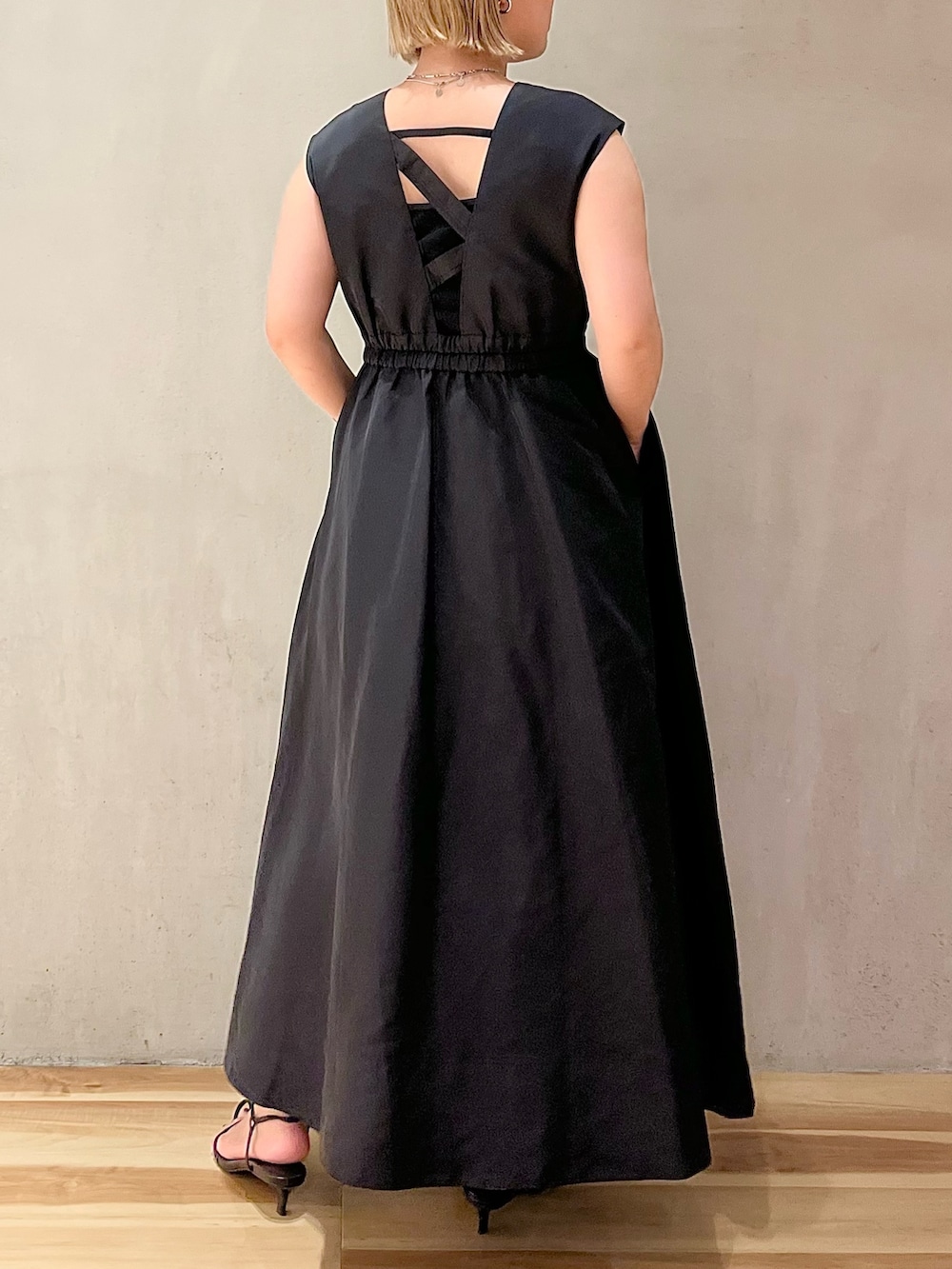 ブラック系のジャンパースカートを着用したレディースの夏コーディネートの2枚目の写真