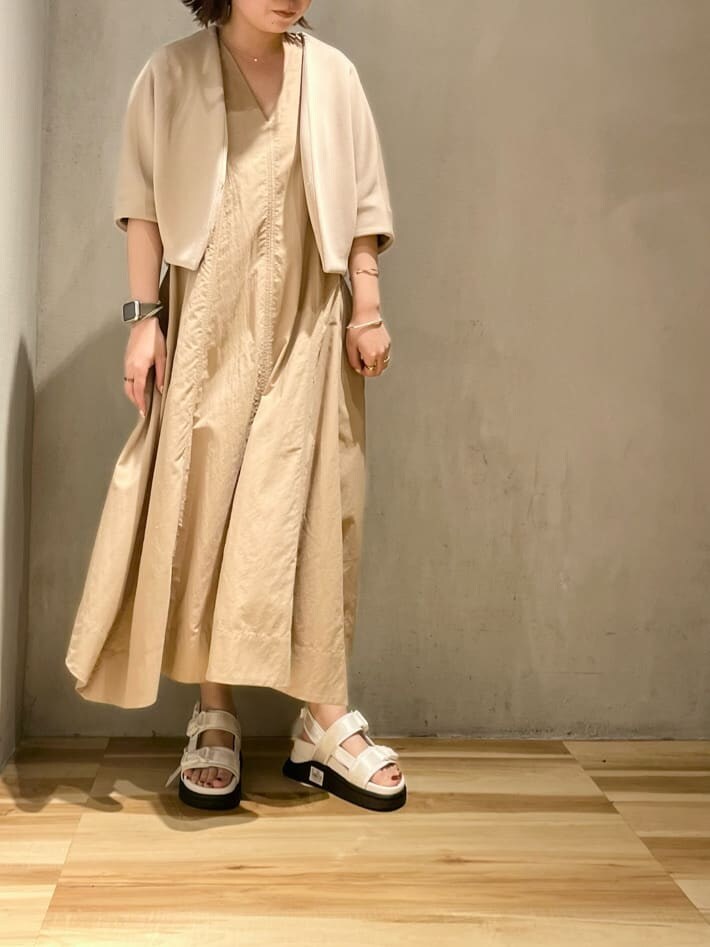 ホワイト系のサンダル、ベージュ系のブルゾン、ベージュ系のワンピースを着用したレディースの春コーディネートの3枚目の写真