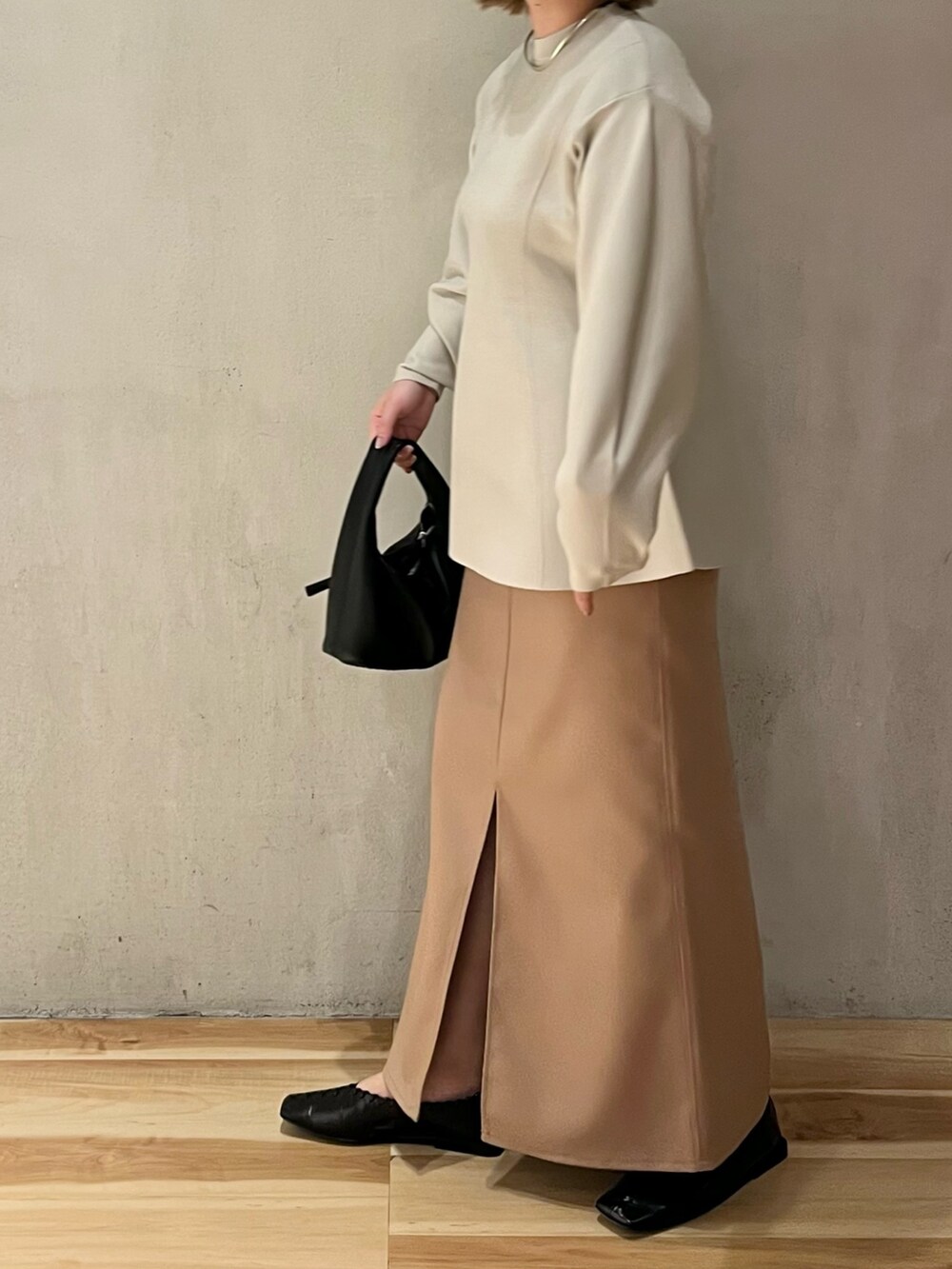 グレー系のニット/セーター、ベージュ系のスカートを着用したレディースの冬コーディネートの4枚目の写真