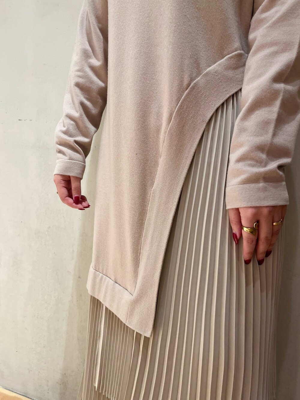 グリーン系のチェスターコート、ブラック系のカーディガン/ボレロ、ベージュ系のワンピースを着用したレディースの冬コーディネートの10枚目の写真