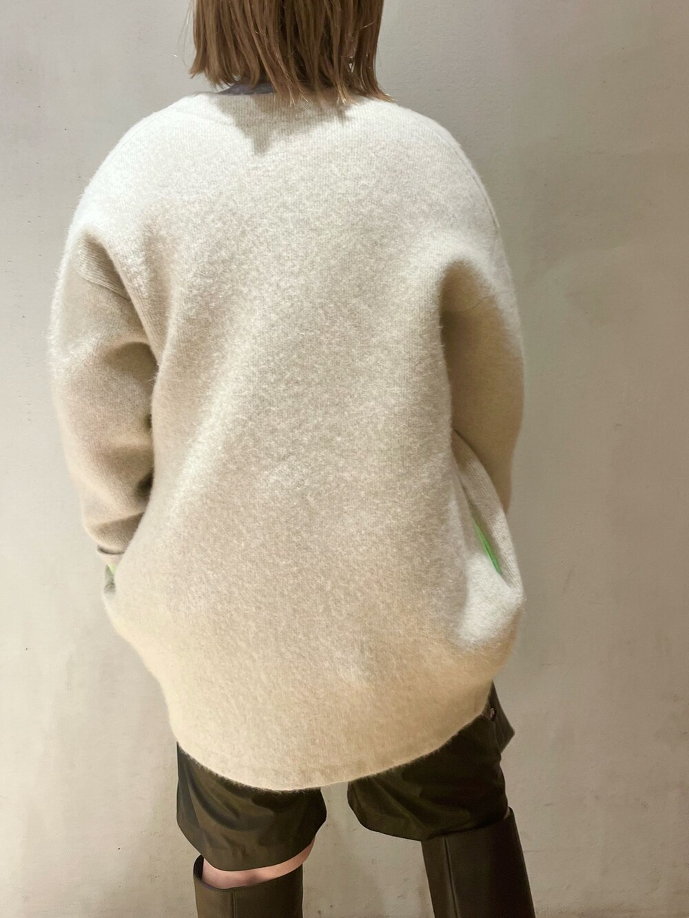 ホワイト系のカーディガン/ボレロ、グレー系のニット/セーターを着用したレディースの冬コーディネートの5枚目の写真