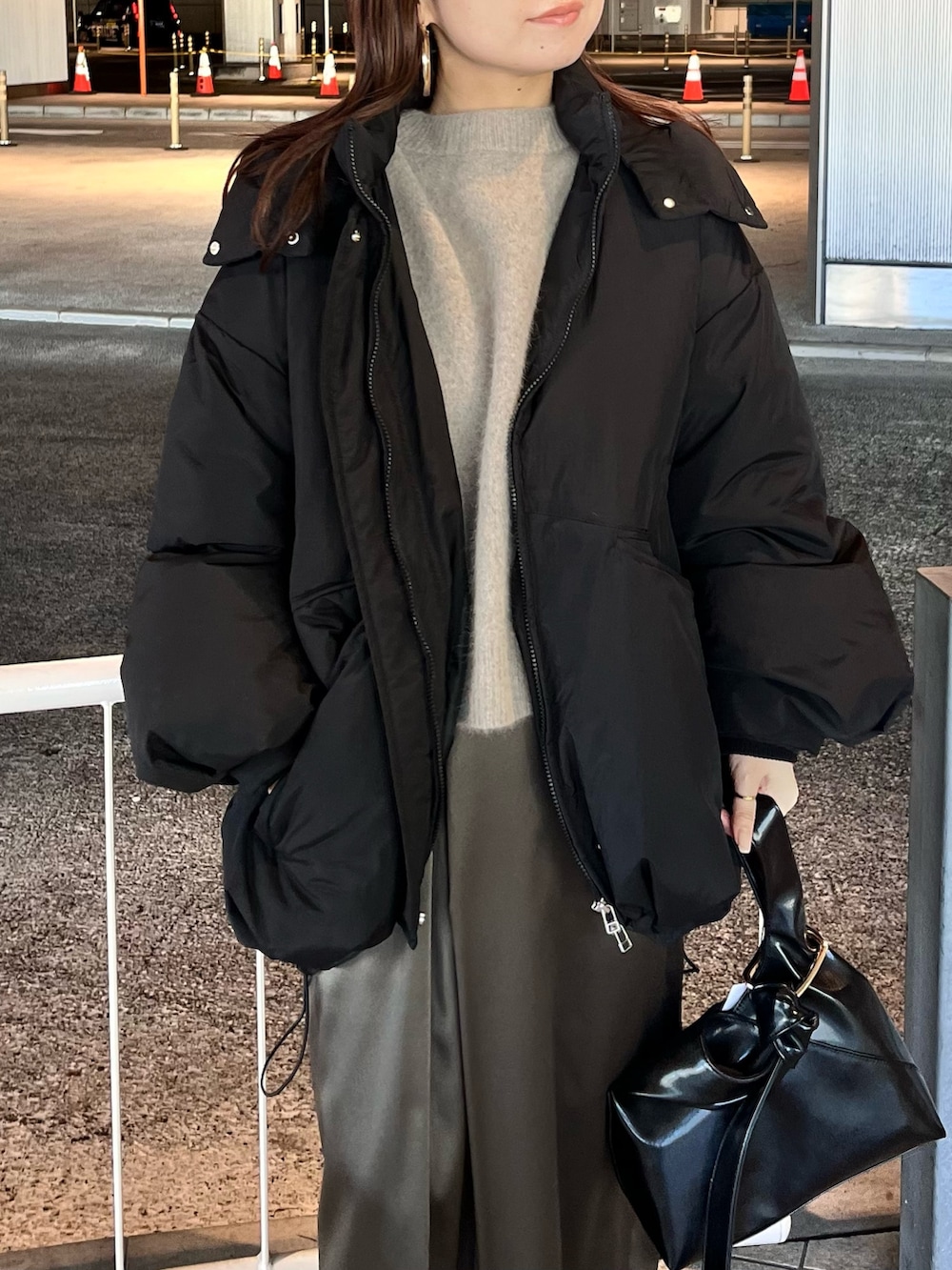 ブラック系のダウンジャケット/コート、ブラウン系のニット/セーター、ブラウン系のスカートを着用したレディースの冬コーディネートの4枚目の写真