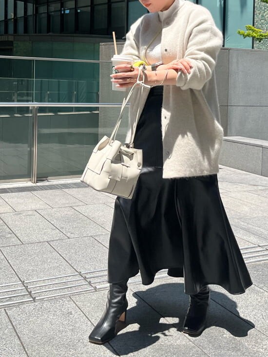ブラック系のスカート、ホワイト系のニット/セーター、ホワイト系のカーディガン/ボレロを着用したレディースの夏コーディネートの5枚目の写真