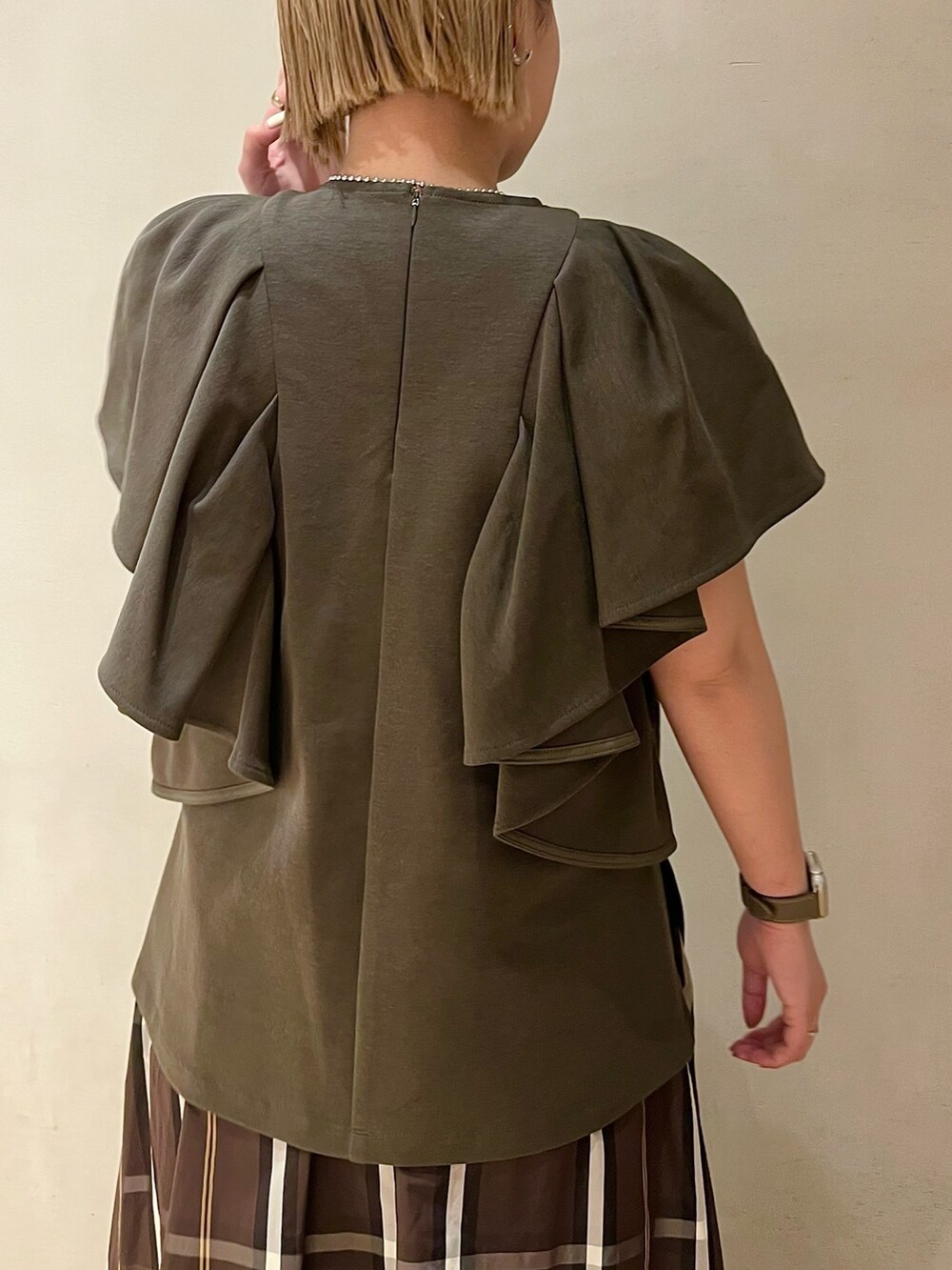 ブラック系のブーツ、グリーン系のTシャツ/カットソー、ブラウン系のスカートを着用したレディースの春コーディネートの5枚目の写真