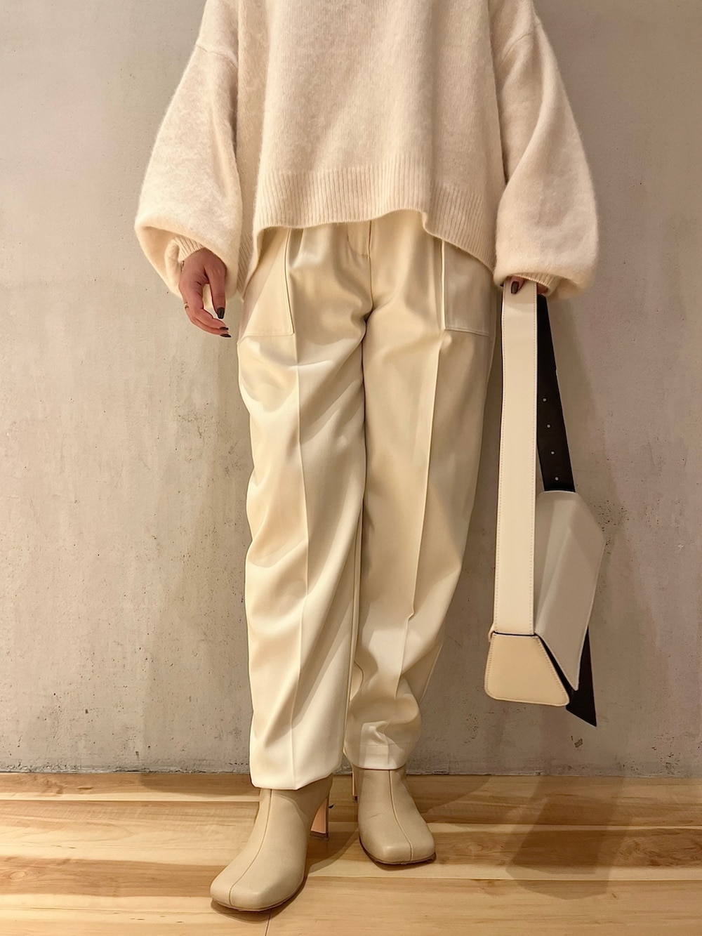 ホワイト系のニット/セーター、ホワイト系のその他パンツ、ベージュ系のブーツを着用したレディースの秋コーディネートの7枚目の写真