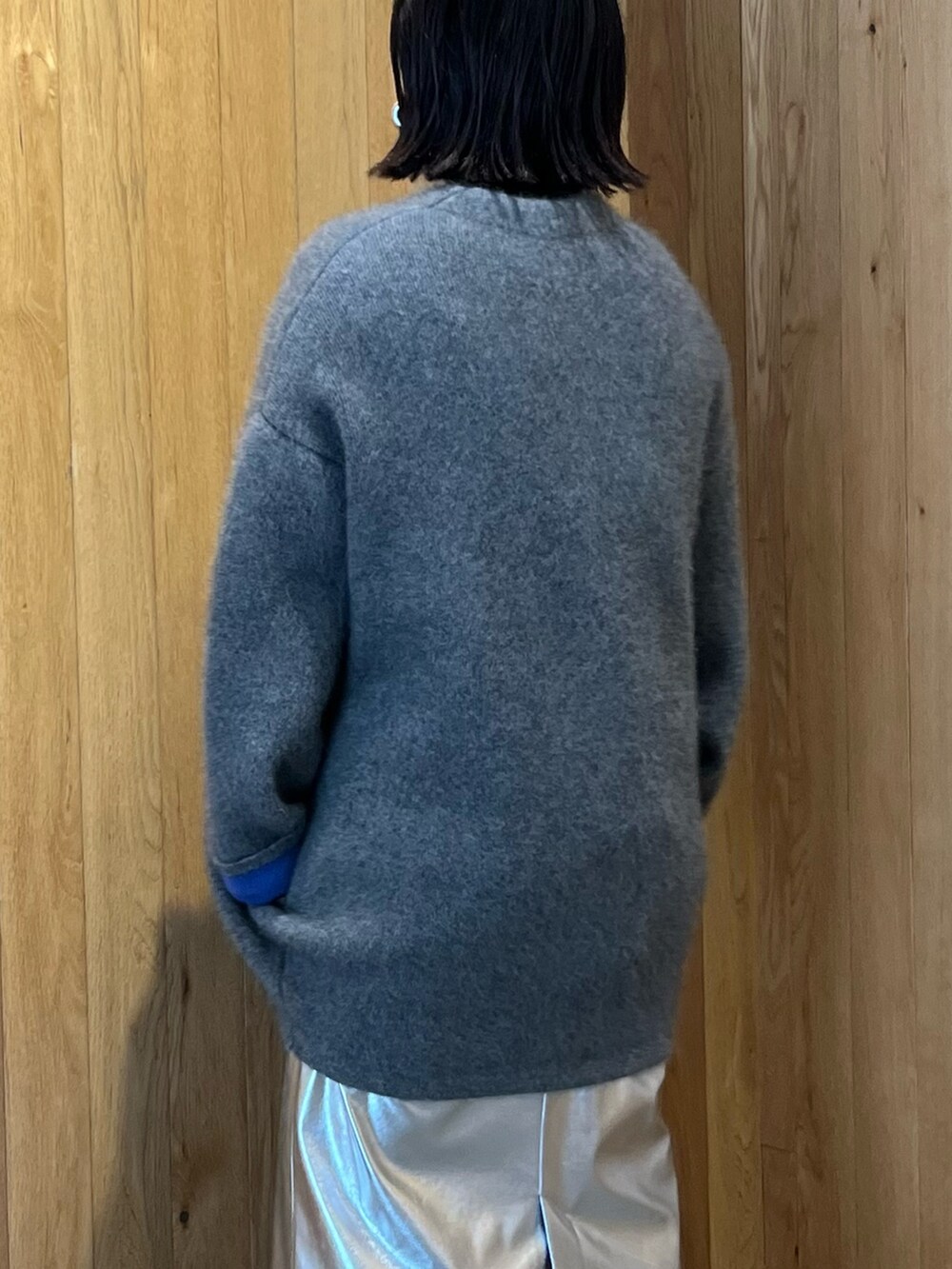 グレー系のカーディガン/ボレロ、シルバー系のスカート、ブラック系のブーツを着用したレディースの秋コーディネートの8枚目の写真