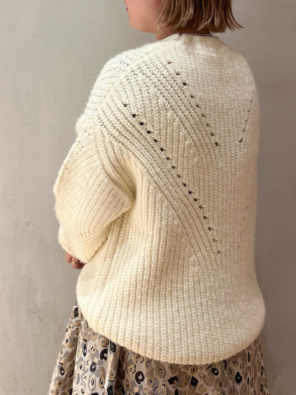 ベージュ系のスカート、ブラック系のハンドバッグ、ホワイト系のニット/セーターを着用したレディースの冬コーディネートの6枚目の写真