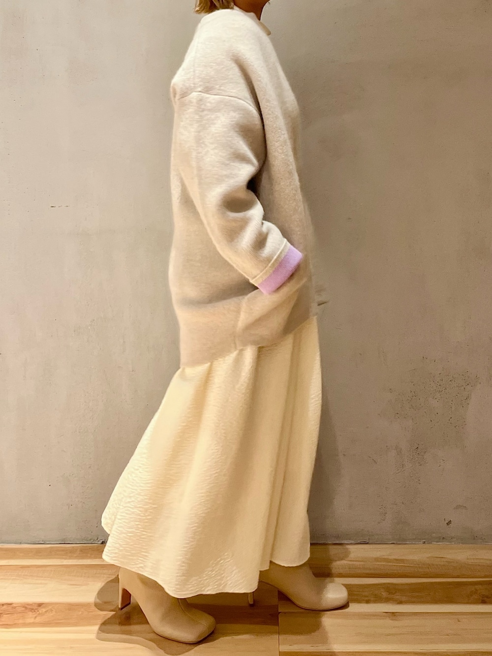 ホワイト系のノーカラージャケット、ホワイト系のワンピース、ベージュ系のブーツを着用したレディースの秋コーディネートの4枚目の写真