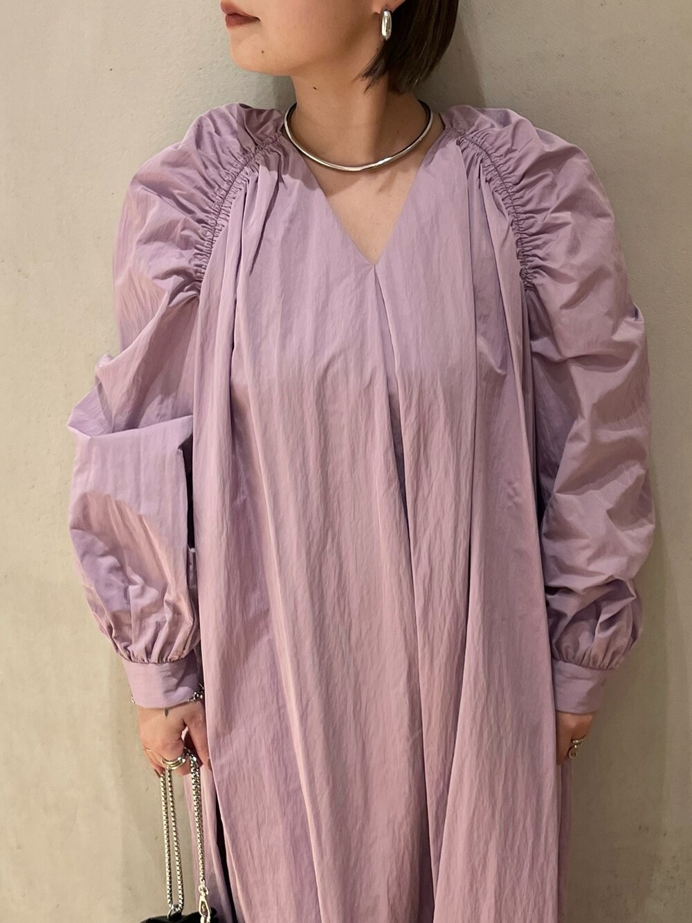 パープル系のワンピース、ブラック系のショルダーバッグを着用したレディースの春コーディネートの5枚目の写真