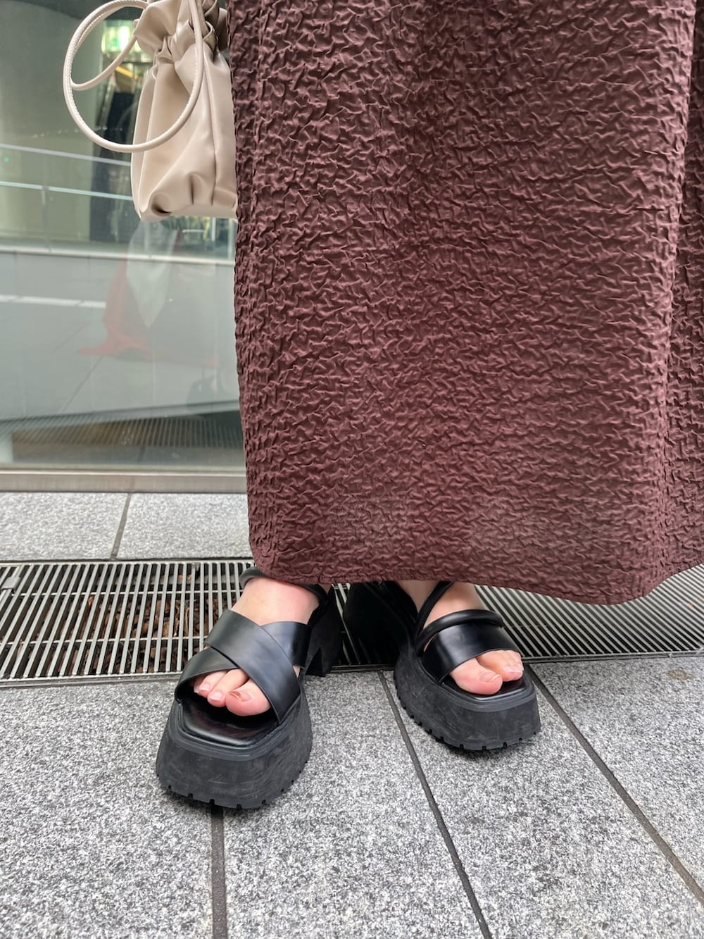 ブラック系のサンダル、ブラウン系のワンピース、シルバー系のネックレスを着用したレディースの冬コーディネートの8枚目の写真