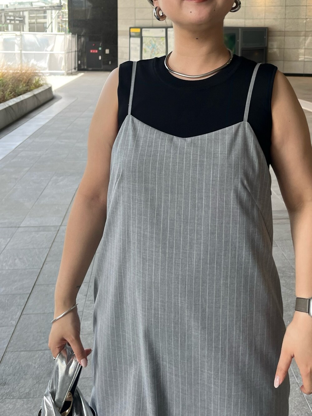 ブラック系のニット/セーター、グレー系のワンピース、シルバー系のハンドバッグを着用したレディースの夏コーディネートの5枚目の写真