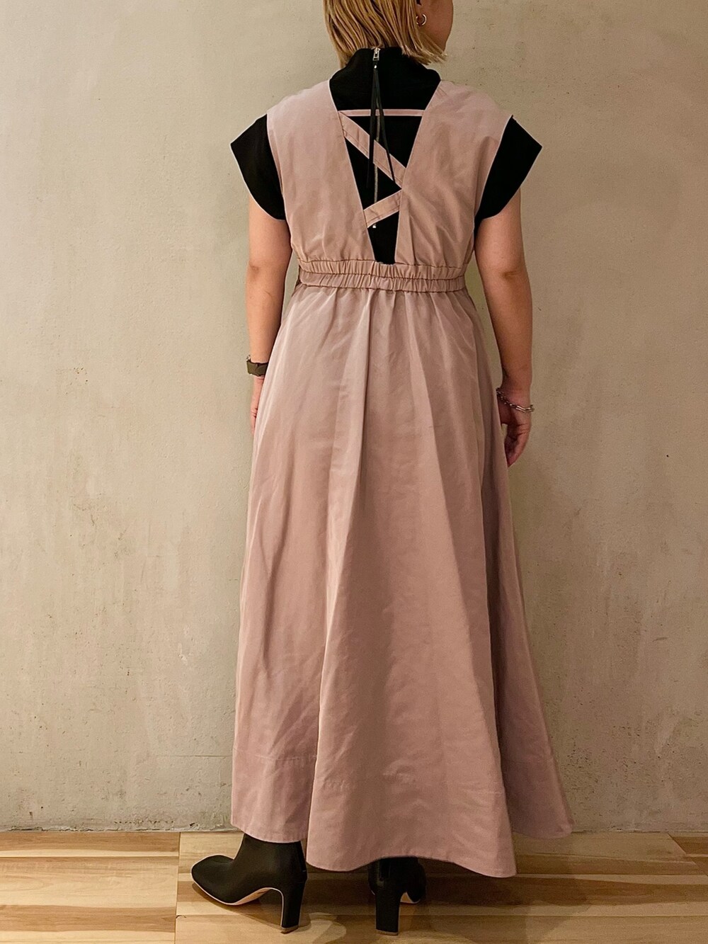 ベージュ系のジャンパースカート、ブラック系のTシャツ/カットソー、ブラック系のブーツを着用したレディースの夏コーディネートの2枚目の写真