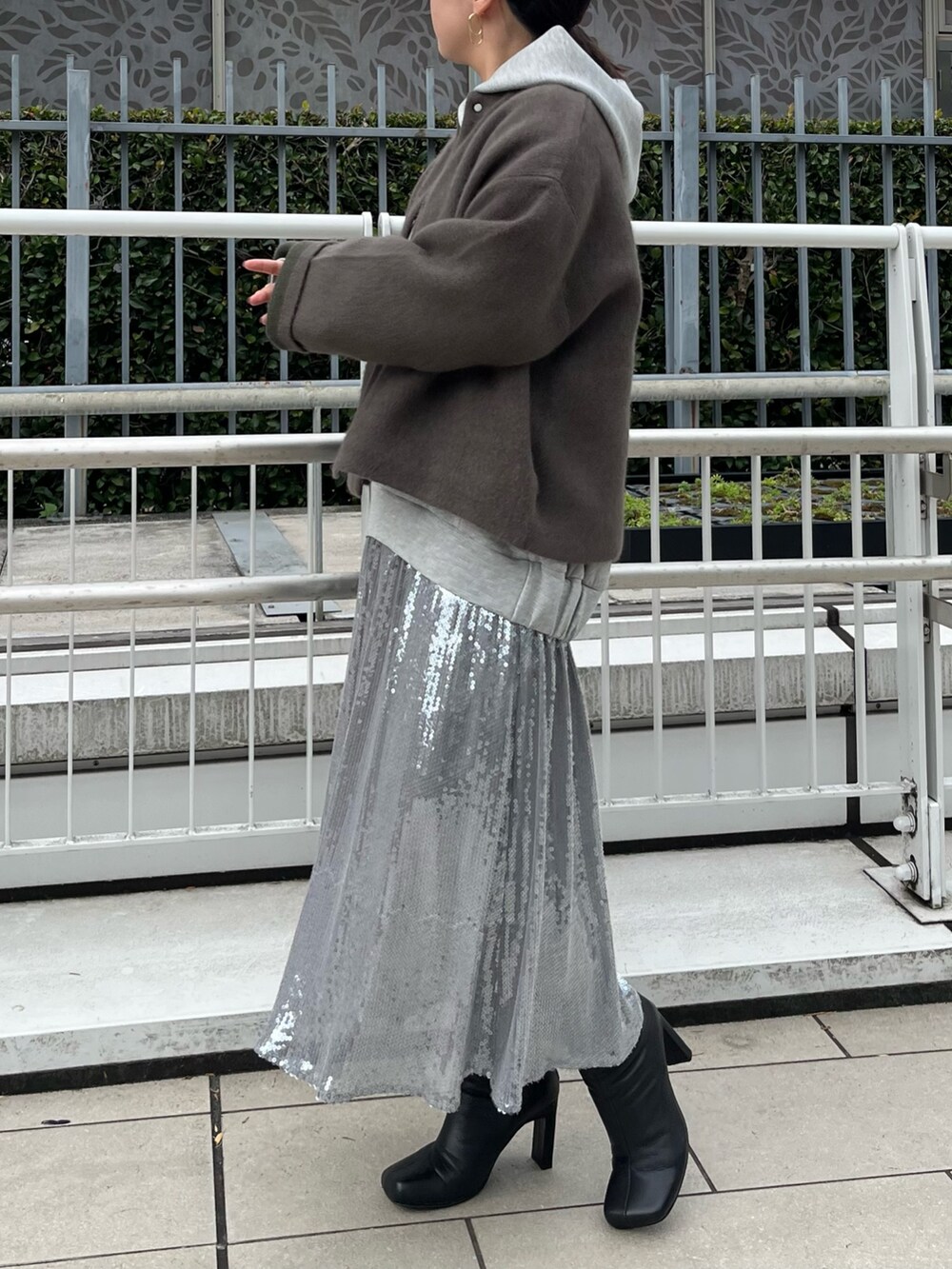 ブラウン系のカーディガン/ボレロ、グレー系のワンピース、ブラック系のブーツを着用したレディースの秋コーディネートの2枚目の写真