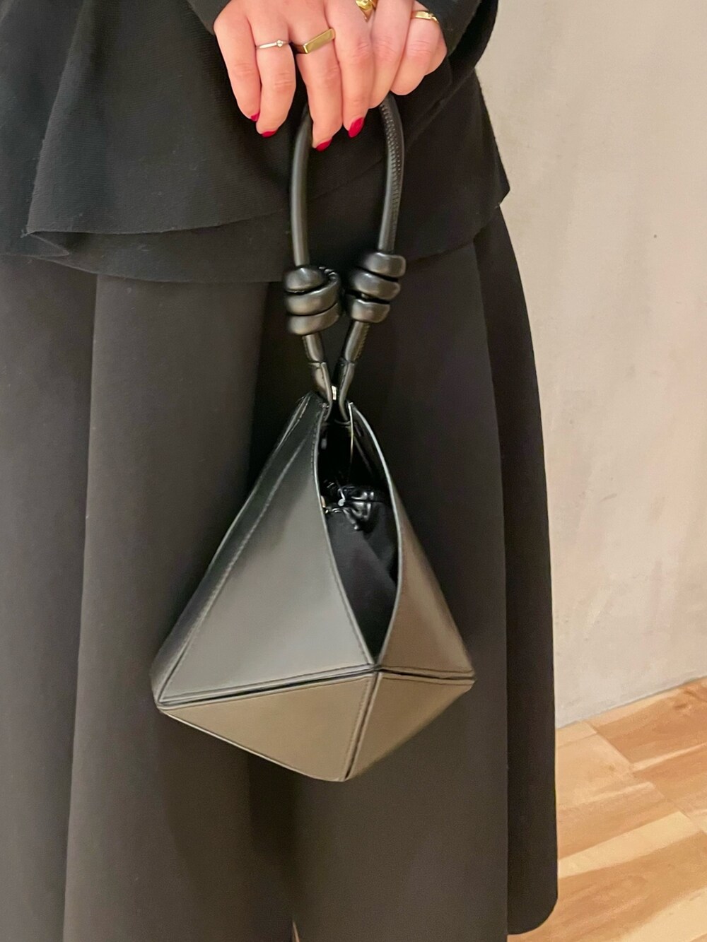 イエロー系のカーディガン/ボレロ、ブラック系のニット/セーター、ブラック系のスカートを着用したレディースの冬コーディネートの10枚目の写真