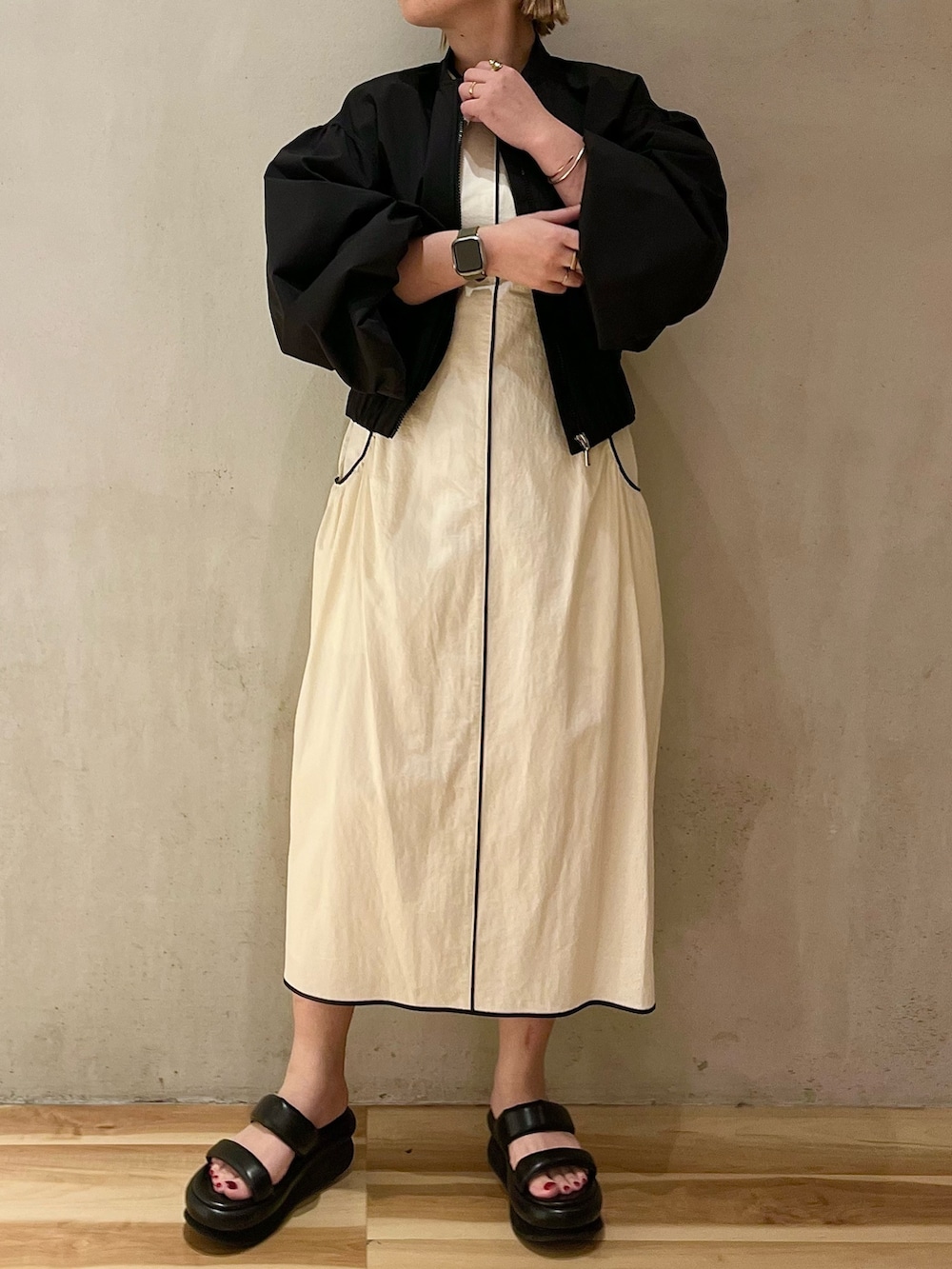 ブラック系のサンダル、ブラック系のブルゾン、ホワイト系のワンピースを着用したレディースの春コーディネートの3枚目の写真