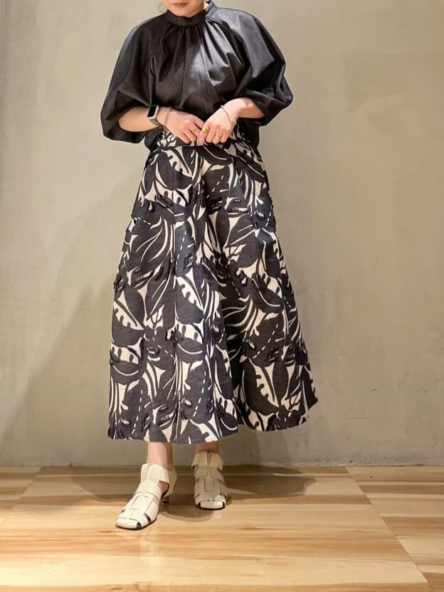 パープル系のニット/セーター、ブルー系のスカート、ブルー系のシャツ/ブラウスを着用したレディースの春コーディネートの2枚目の写真