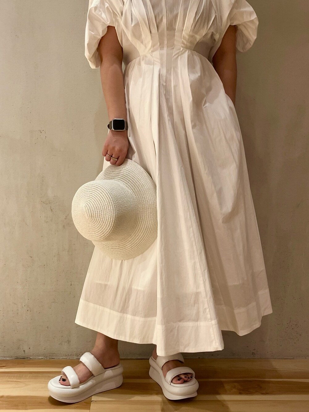 ホワイト系のワンピース、ホワイト系のサンダル、ホワイト系のハットを着用したレディースの春コーディネートの8枚目の写真