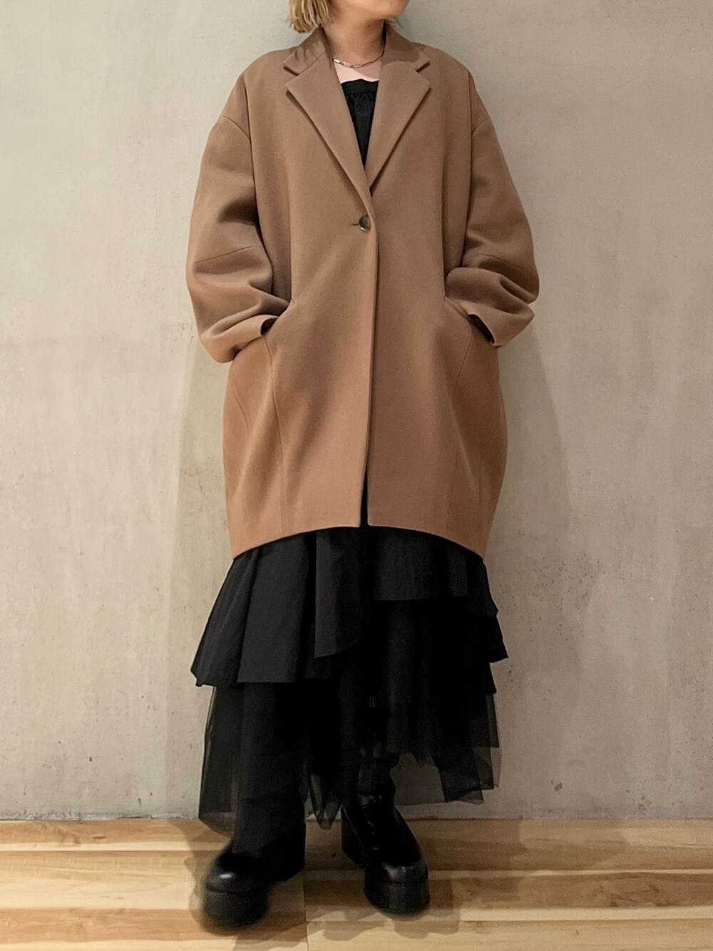 ブラック系のシャツ/ブラウス、ブラック系のスカート、ブラック系のブーツを着用したレディースの秋コーディネートの2枚目の写真