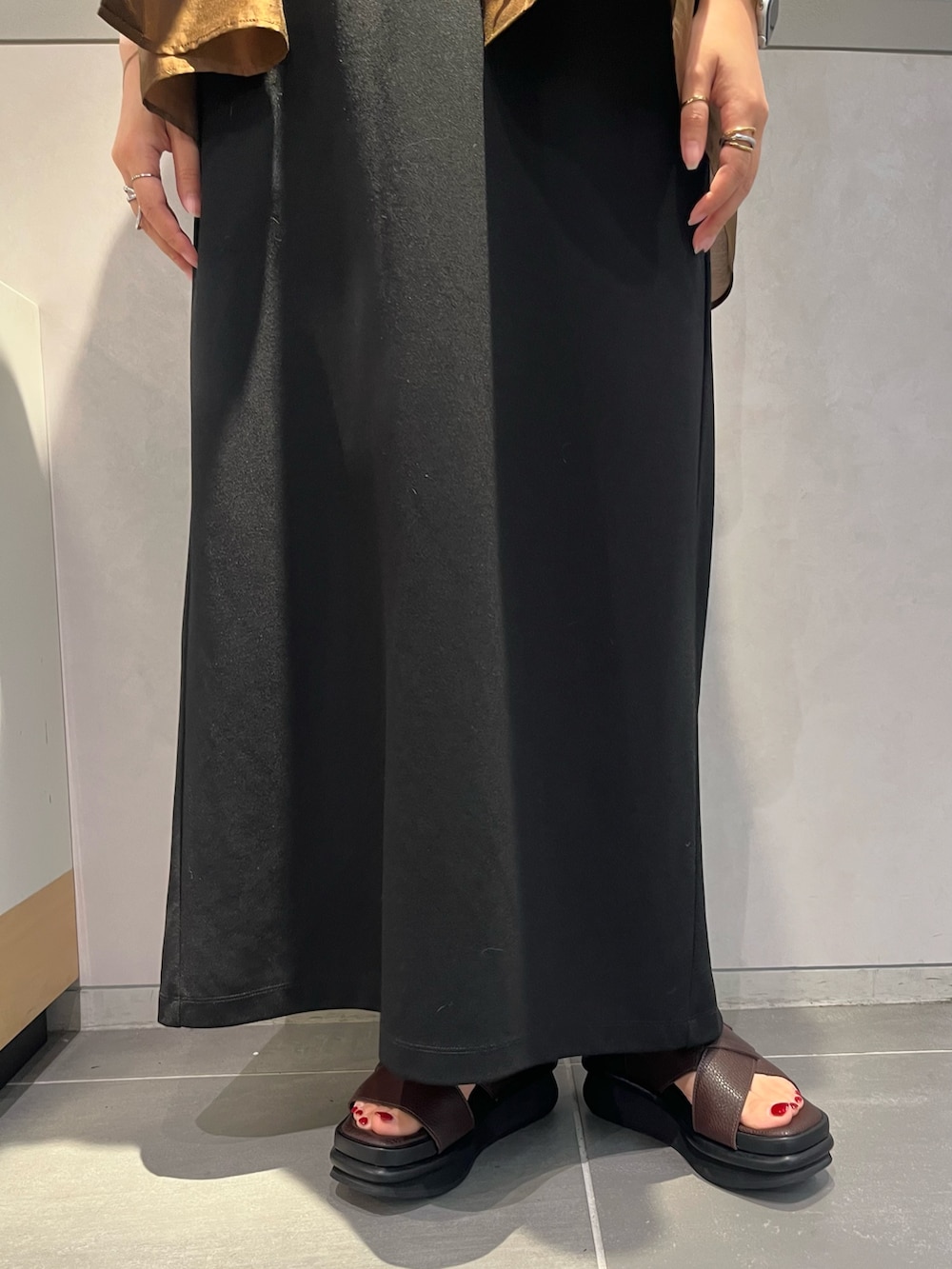 ブラウン系のシャツ/ブラウス、ブラック系のワンピース、ブラウン系のサンダルを着用したレディースの夏コーディネートの6枚目の写真