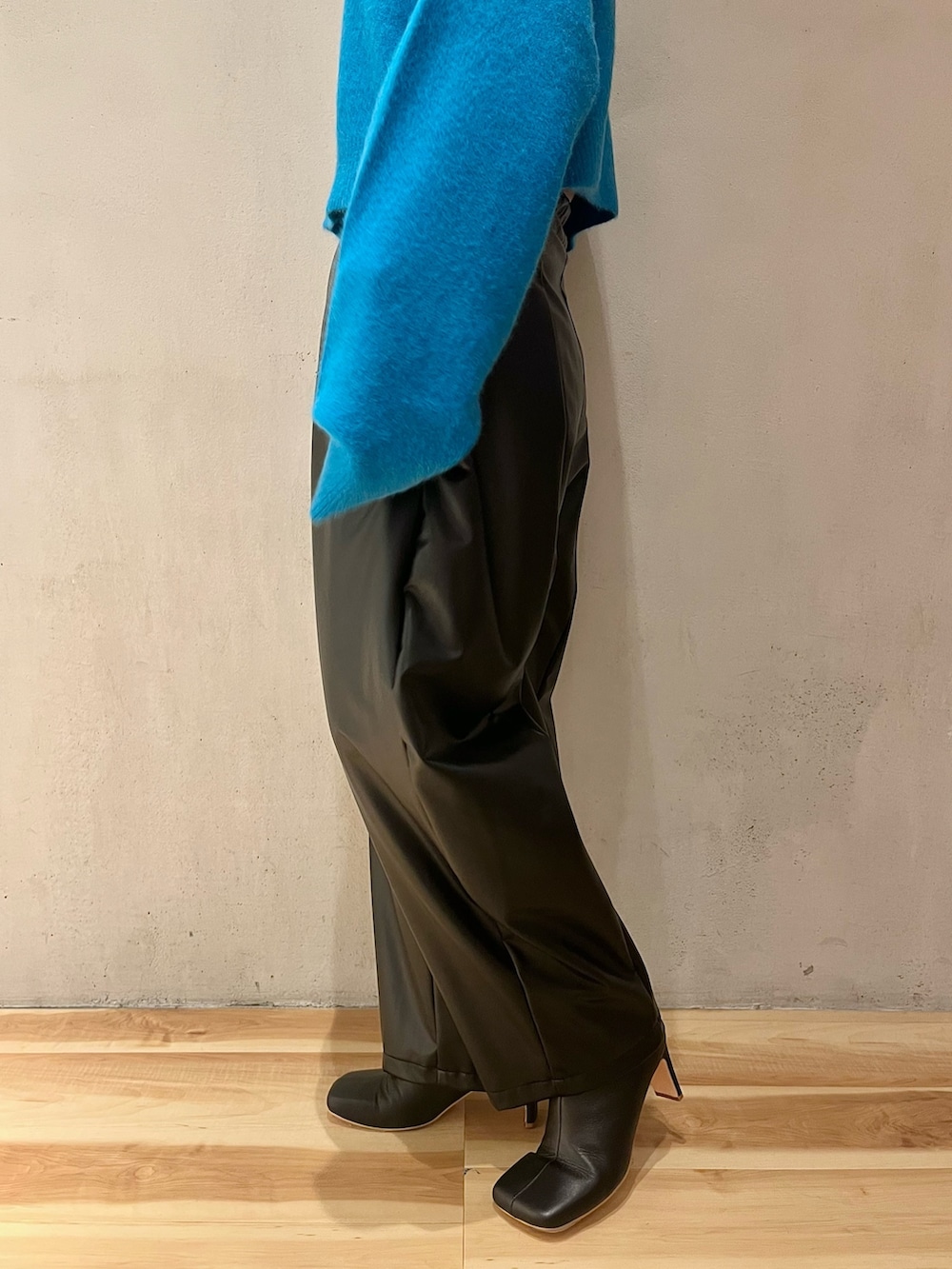 ブルー系のニット/セーター、ブラック系のその他パンツ、ブラック系のブーツを着用したレディースの秋コーディネートの9枚目の写真