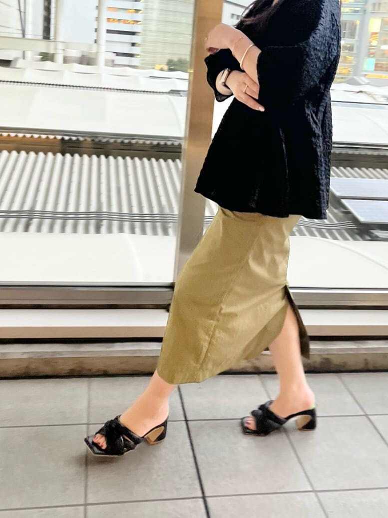 ブラック系のシャツ/ブラウス、ブラック系のサンダル、ベージュ系のスカートを着用したレディースの春コーディネートの5枚目の写真