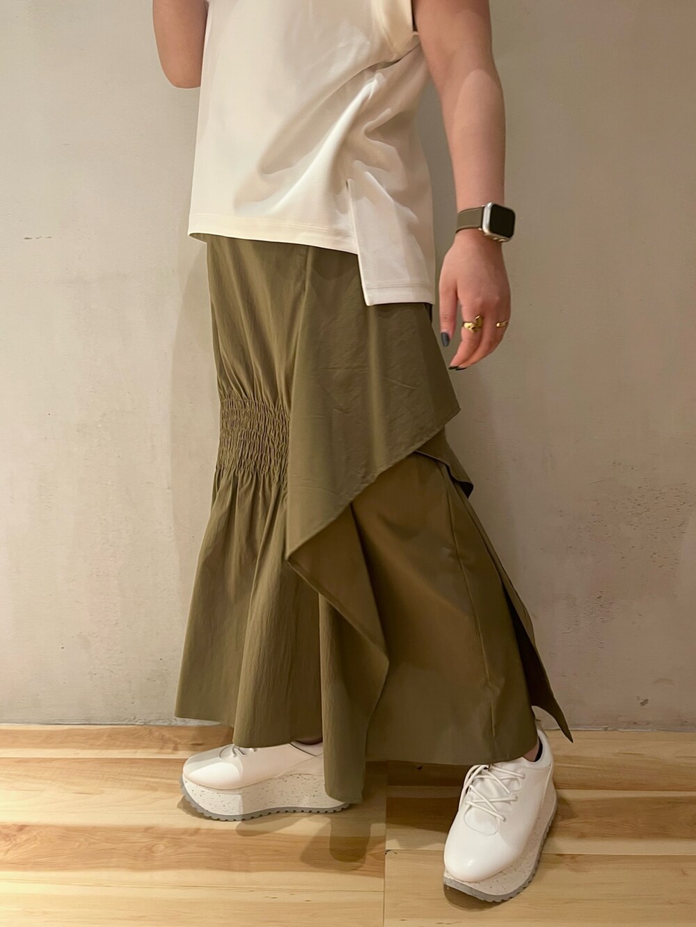 グリーン系のスカート、ホワイト系のTシャツ/カットソー、ホワイト系のスニーカーを着用したレディースの夏コーディネートの8枚目の写真