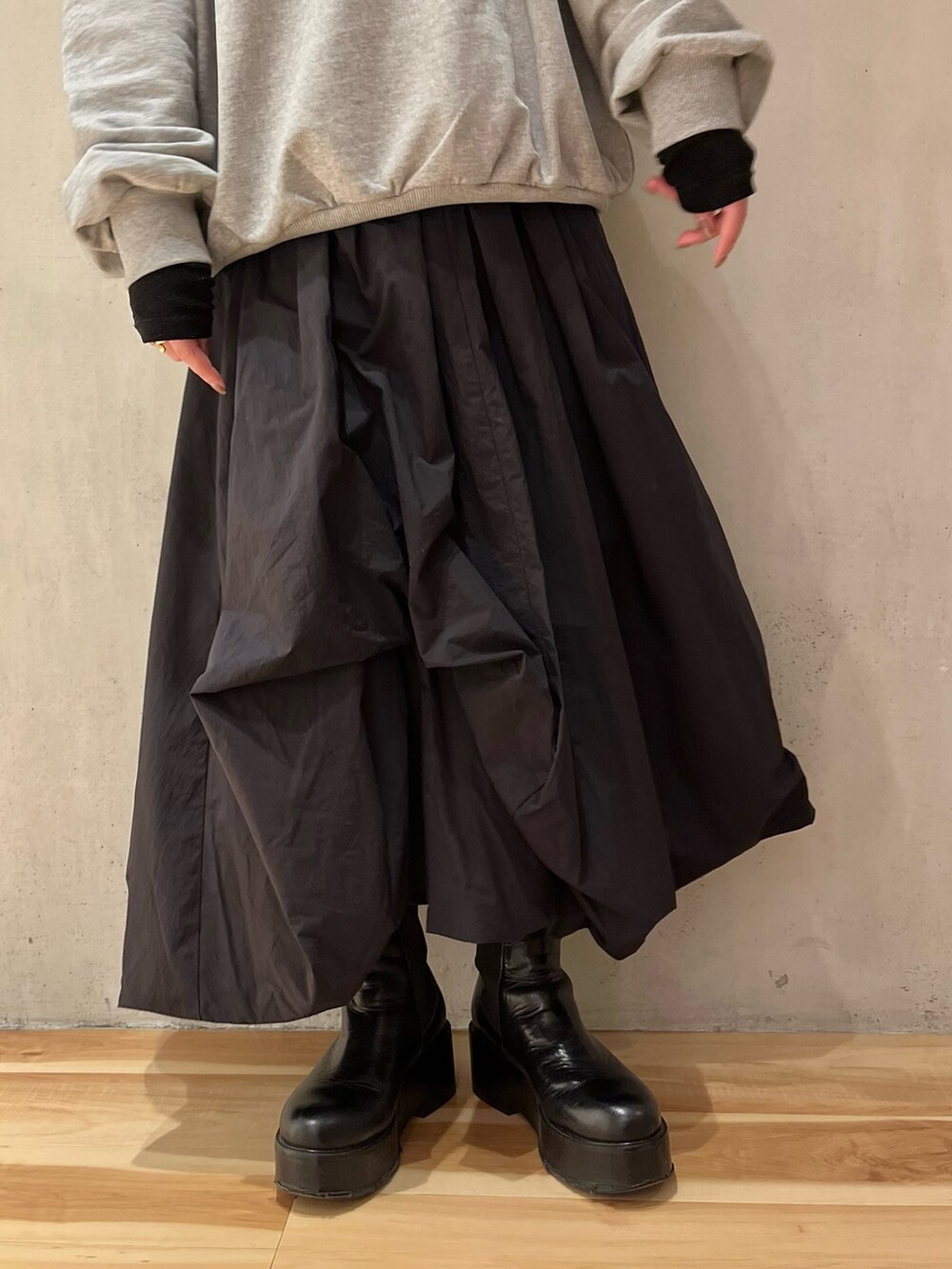 グレー系のスウェット、ブラック系のTシャツ/カットソー、ブラック系のスカートを着用したレディースの冬コーディネートの9枚目の写真