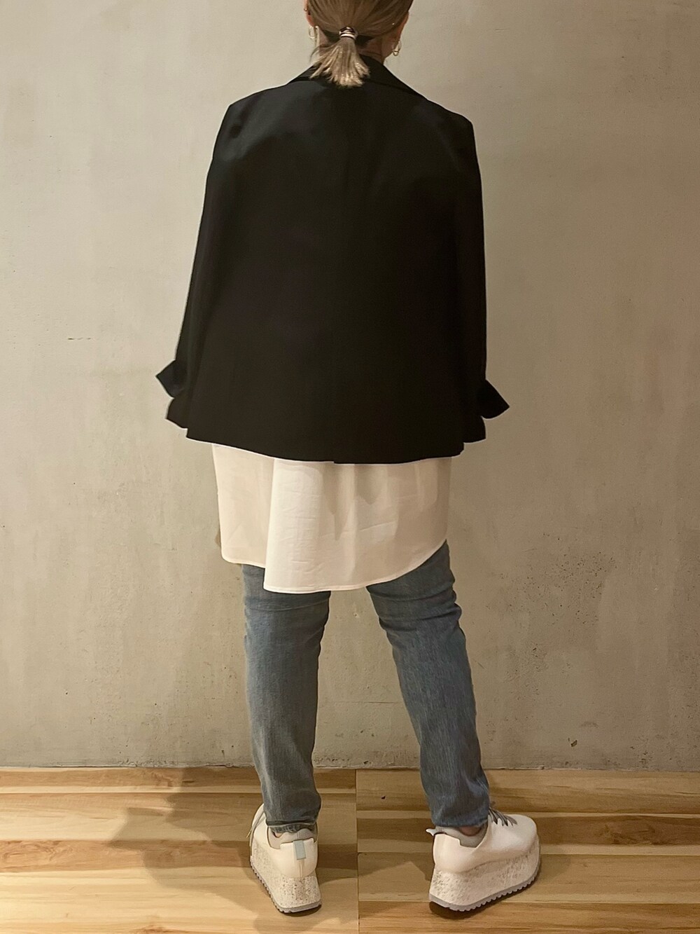 ブラック系のテーラードジャケット、ホワイト系のシャツ/ブラウス、ブルー系のデニムパンツを着用したレディースの冬コーディネートの2枚目の写真