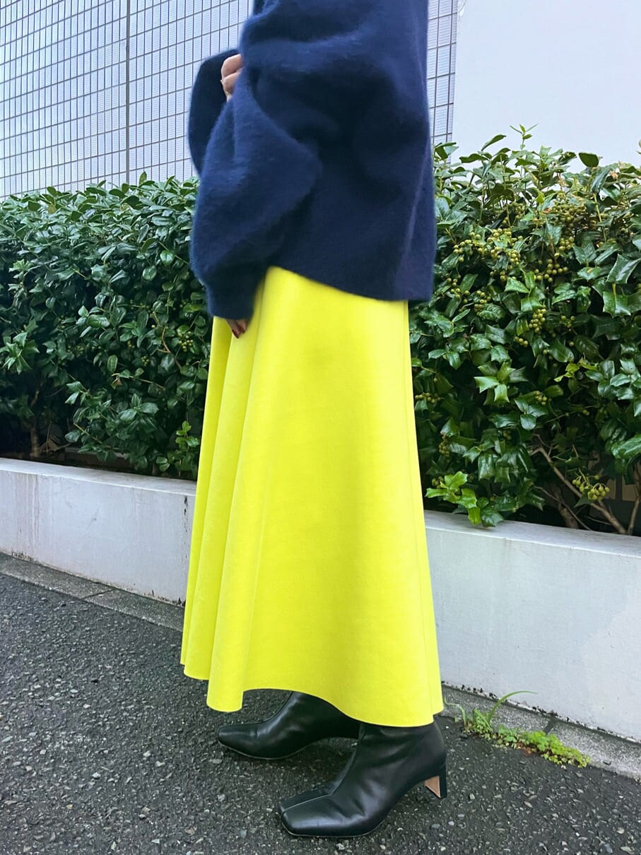 ベージュ系のダウンジャケット/コート、ブルー系のニット/セーター、イエロー系のスカートを着用したレディースの秋コーディネートの9枚目の写真