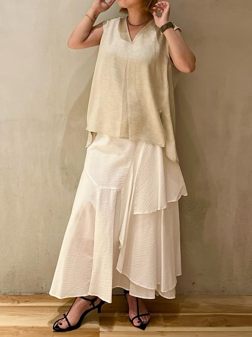 ベージュ系のシャツ/ブラウス、ホワイト系のブルゾン、ゴールド系のネックレスを着用したレディースの夏コーディネートの3枚目の写真