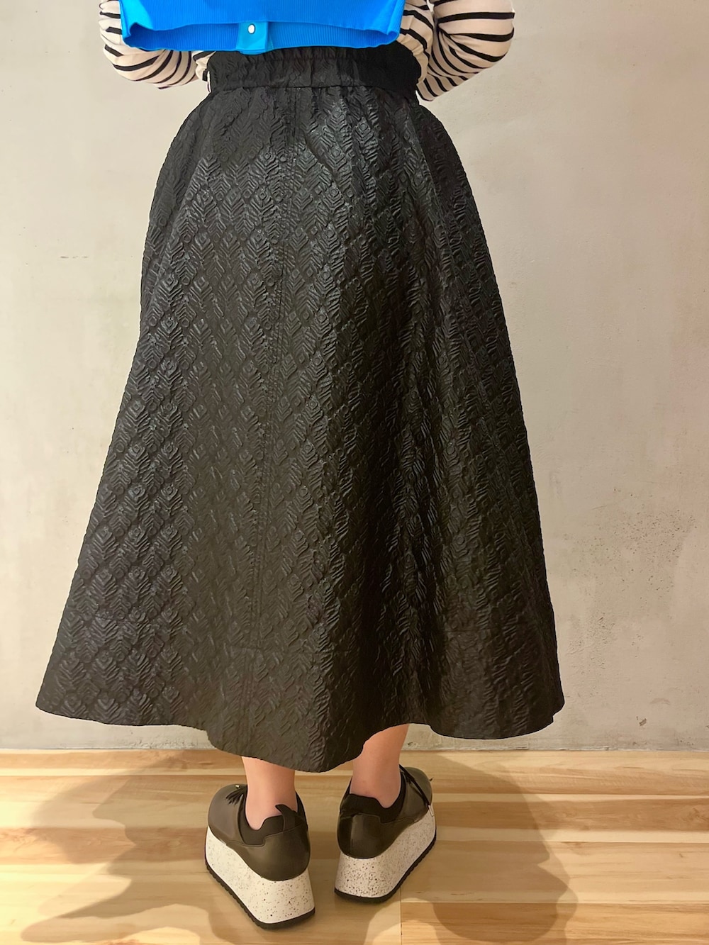 ブルー系のカーディガン/ボレロ、ブラック系のスカート、ブラック系のスニーカーを着用したレディースの春コーディネートの6枚目の写真