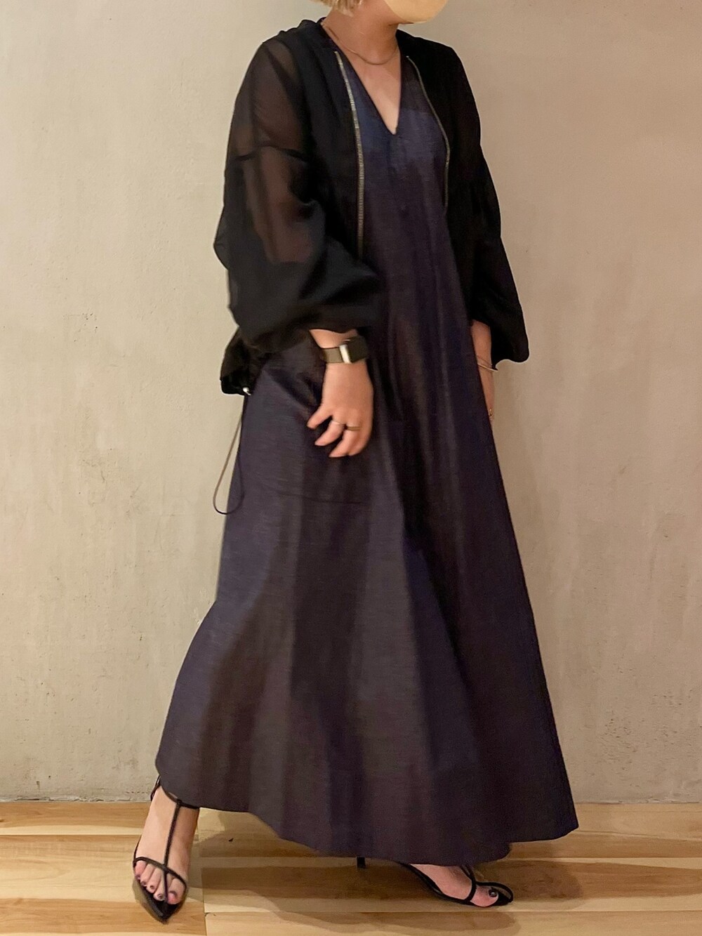 ブラック系のブルゾン、ブルー系のワンピース、ゴールド系のネックレスを着用したレディースの春コーディネートの4枚目の写真