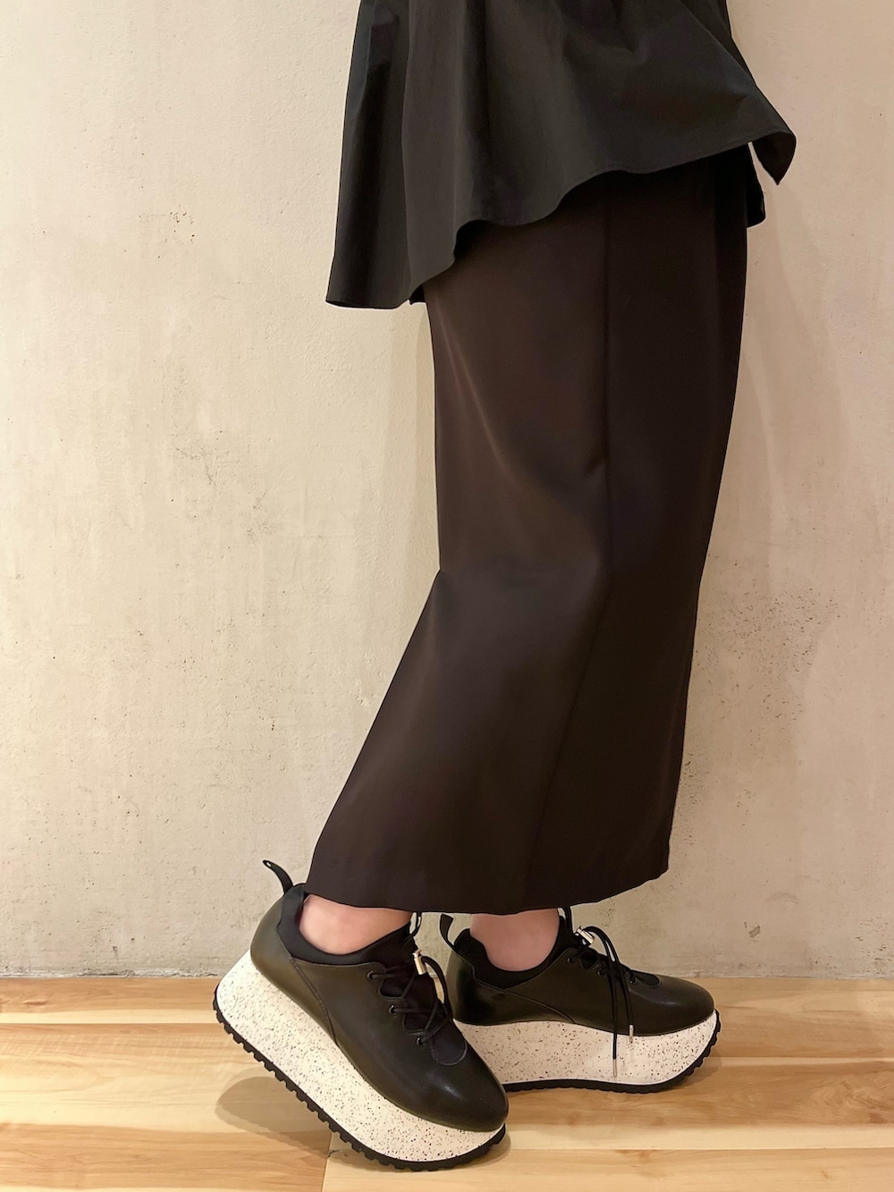 ブラック系のシャツ/ブラウス、グリーン系のニット/セーター、ブラック系のスカートを着用したレディースの冬コーディネートの9枚目の写真