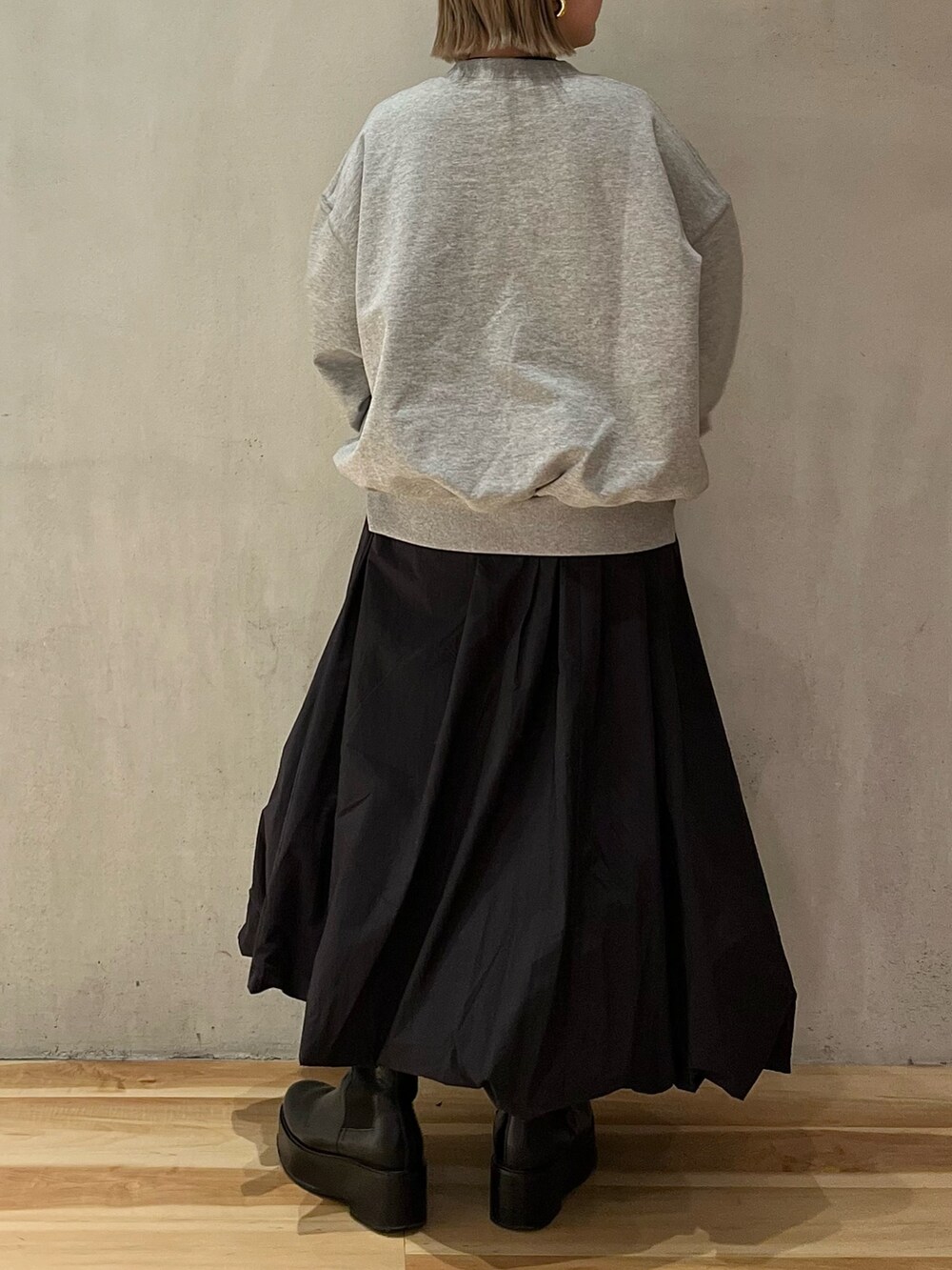 グレー系のスウェット、ブラック系のTシャツ/カットソー、ブラック系のスカートを着用したレディースの冬コーディネートの4枚目の写真
