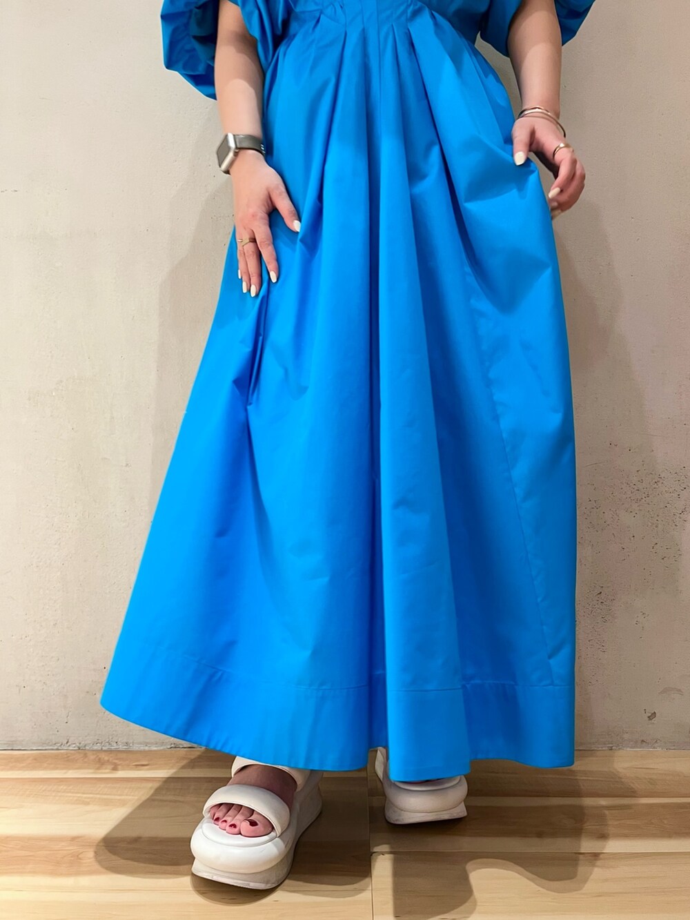 ブルー系のワンピース、ホワイト系のサンダル、ゴールド系のネックレスを着用したレディースの冬コーディネートの7枚目の写真