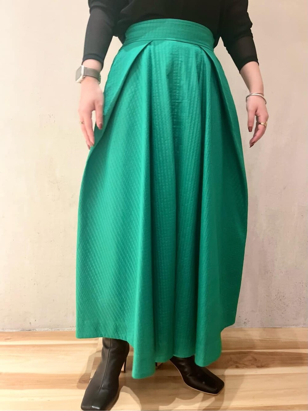 グリーン系のスカート、ブラック系のブーツ、ブラック系のTシャツ/カットソーを着用したレディースの夏コーディネートの6枚目の写真